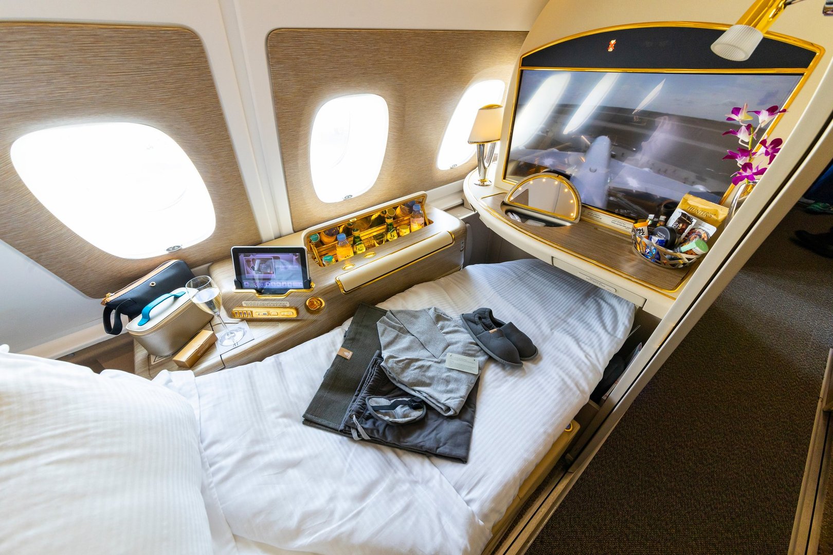Berlin, Germany - June 7, 2024: Luxurious travel style onboard of Emirates Airbus A380 in First Class. Window seat with sleeping bed and amenity kit.