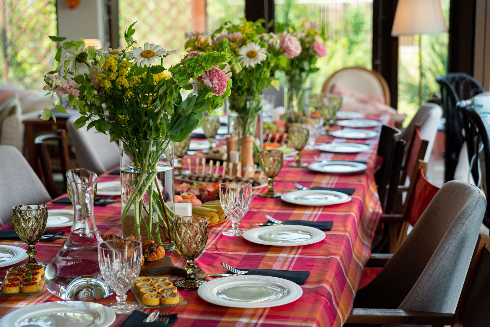 A beautifully arranged dining table showcases vibrant floral centerpieces and fine glassware, creating a warm and inviting atmosphere perfect for gatherings or special occasions.