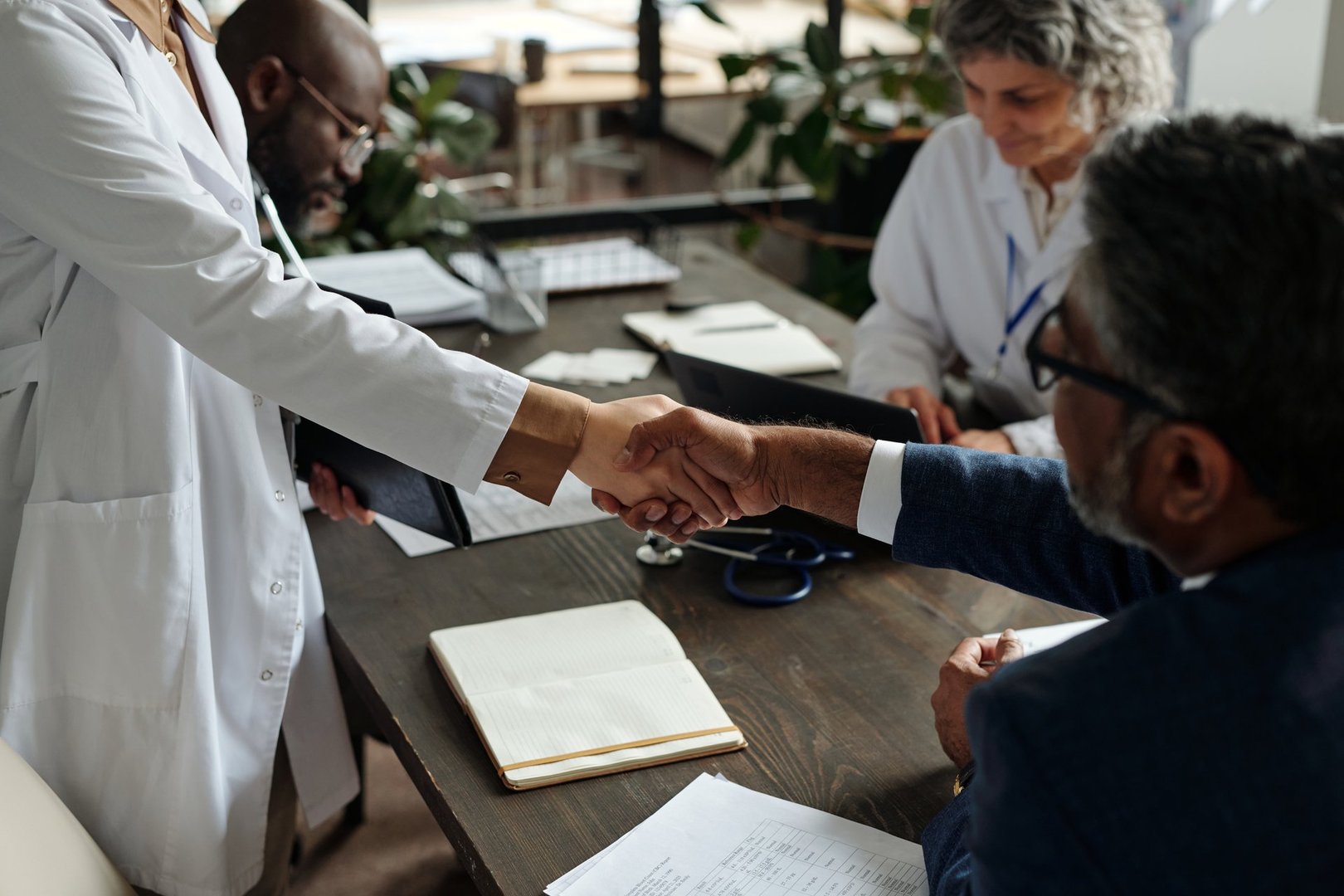 Woman in lab coat shaking hands with man in suit