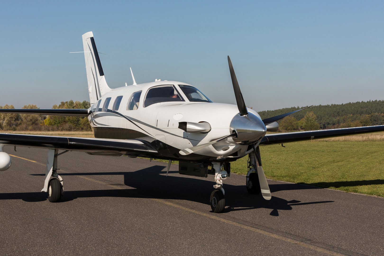 Small private single-engine piston aircraft on runway during sunset
