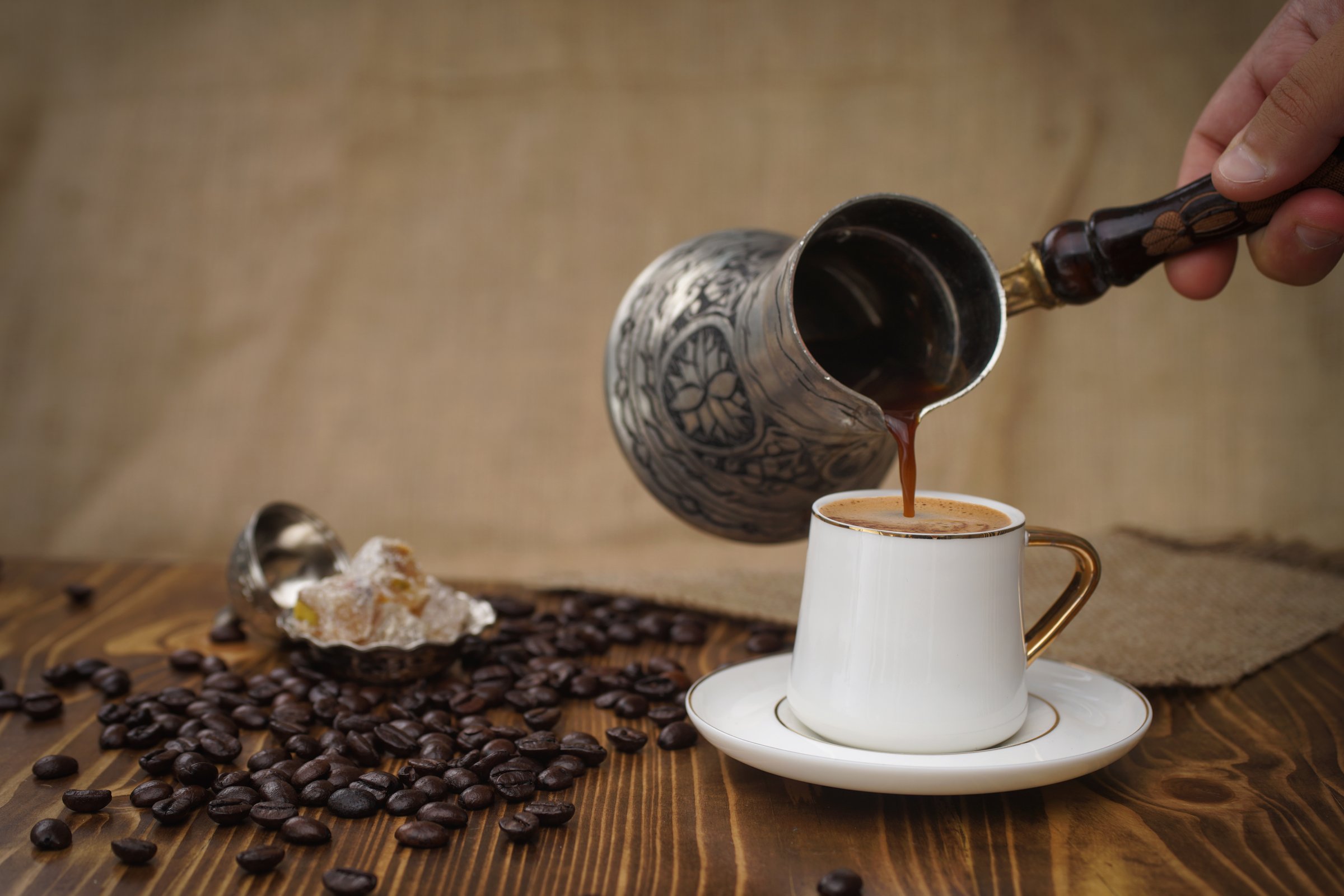 Hot Turkish coffee on wooden floor, Turkish delight next to it.