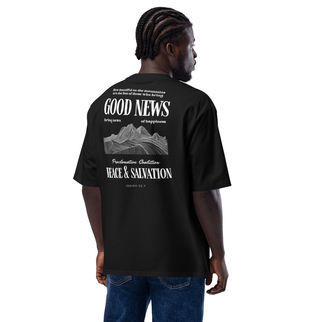 Man wearing a black T-shirt with "GOOD NEWS" and religious text on the back, standing against a white background.