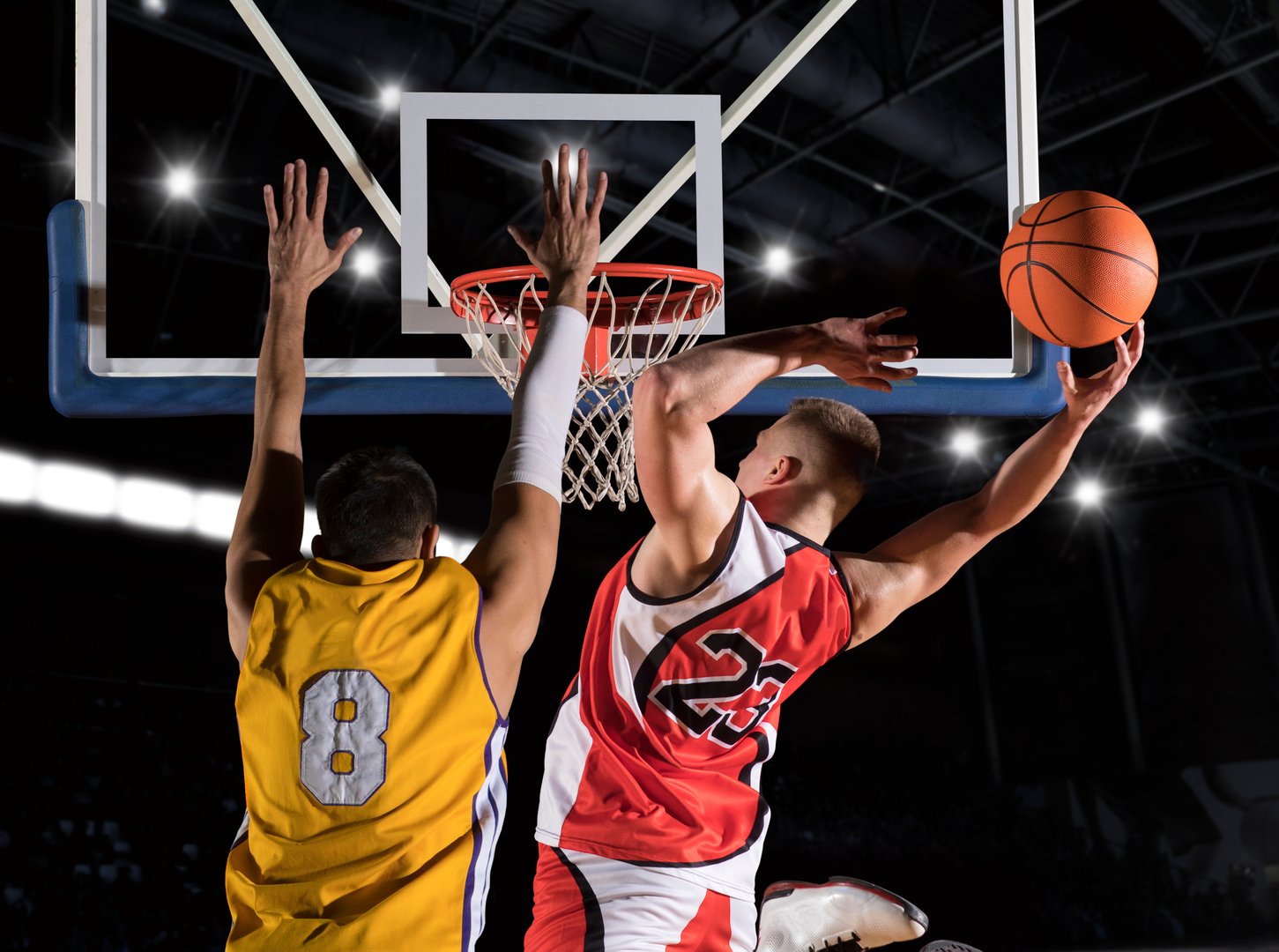 Two basketball players in action in gym