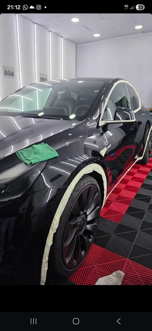 professional man wipes and dries a car with a rag. Car wrapping with protective film