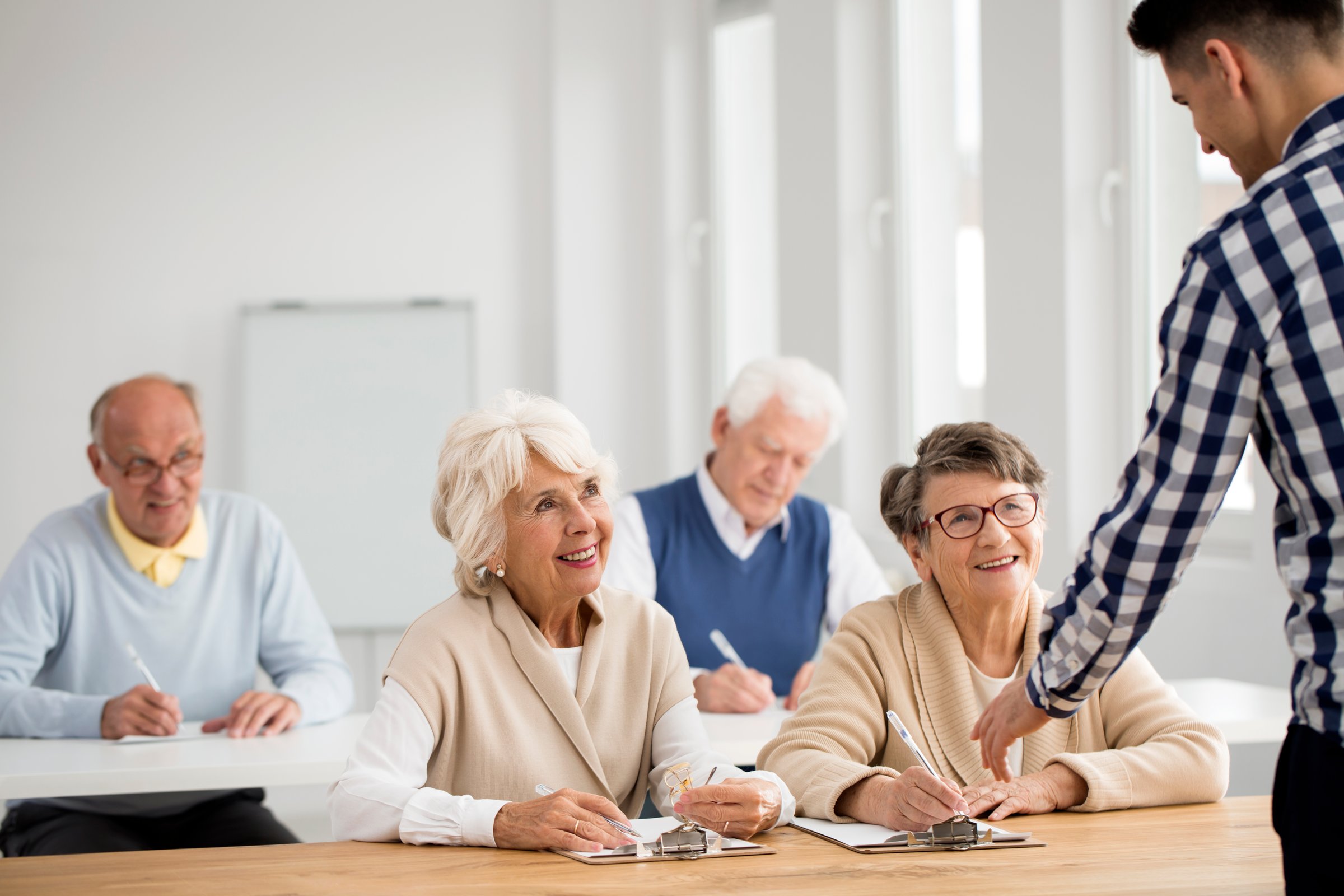 Young lecturer explaining IT problem to senior ladies