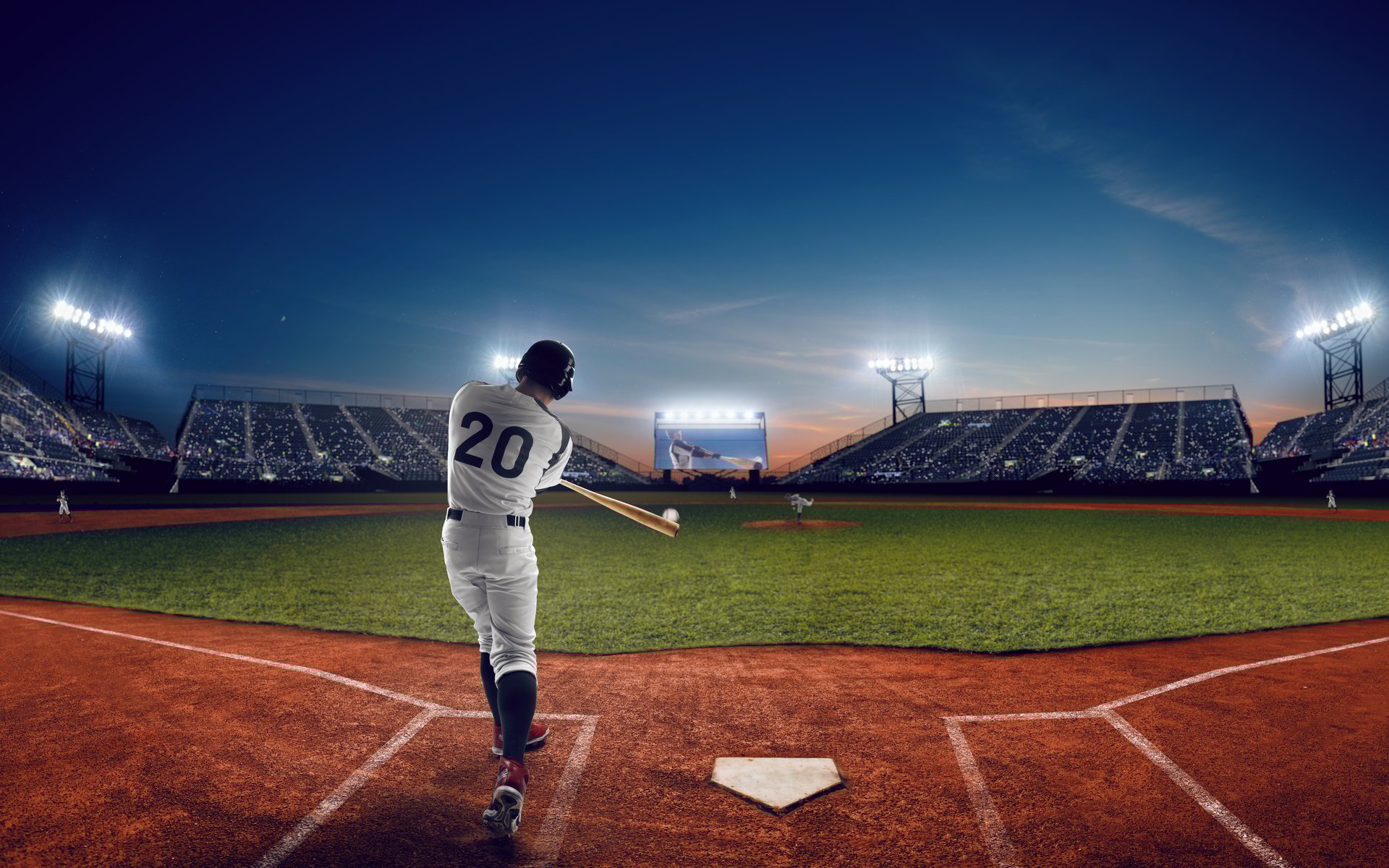 Baseball player at professional baseball stadium in evening during a game.