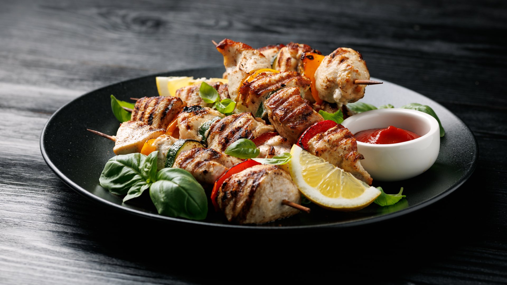 Chicken kebab skewers on a plate with vegetables. Mediterranean healthy food.