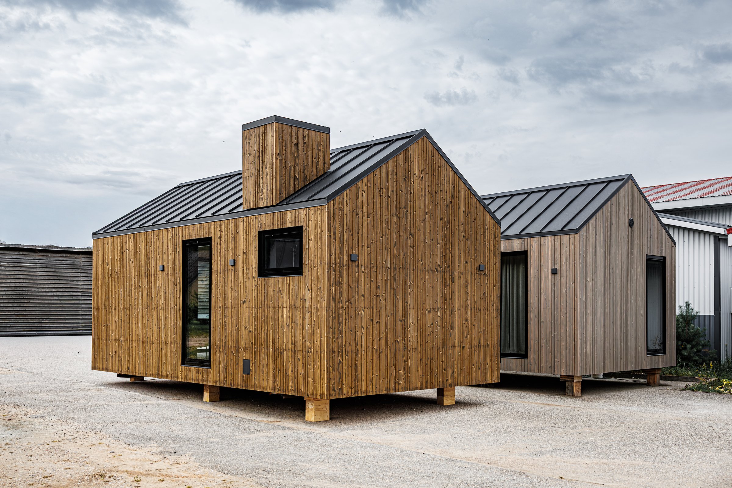 Two modern wooden tiny houses with vertical cladding