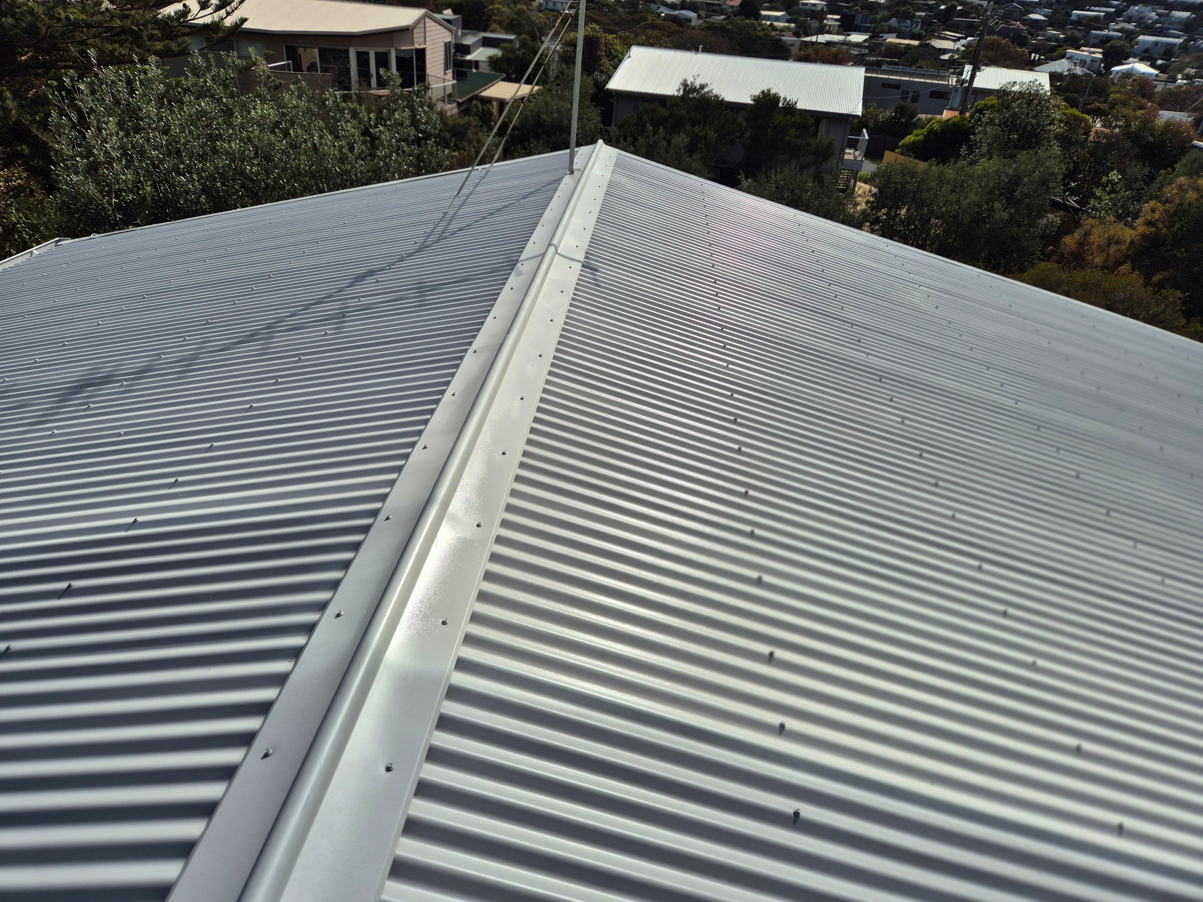Professional metal roof painting application by Quality Painting Group