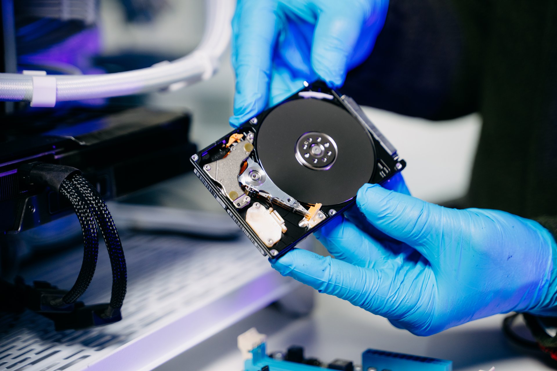 Closeup of technician repairing hard disk for data recovery in modern tech lab, symbolizing innovation, IT maintenance, and digital information technology.