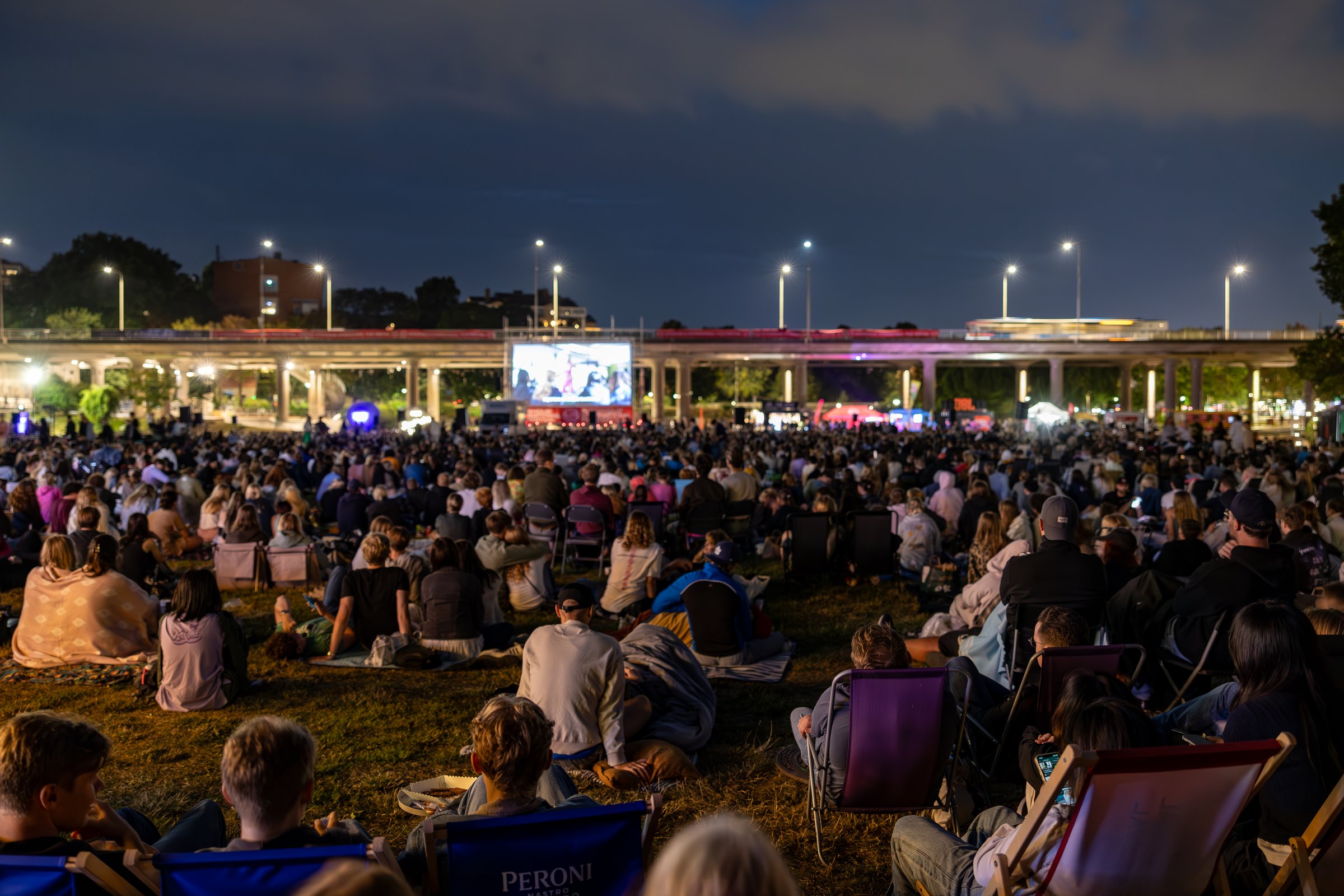Stockholm, Sweden August 15, 2024 A large public crowd of people attend an outdoor public screening of a movie in the summer in the Ralis Park.