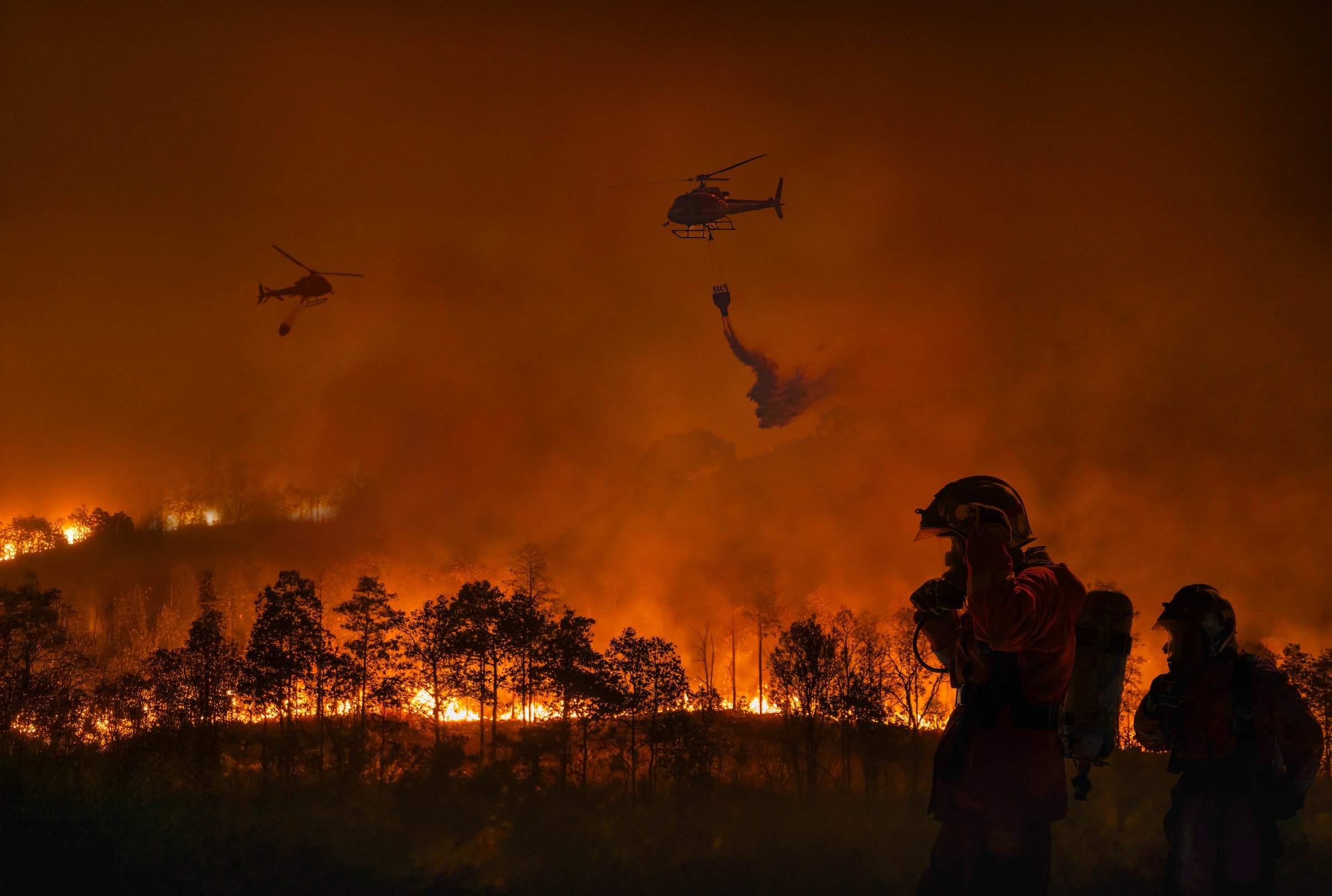 Fire fighting helicopter carry water bucket to extinguish the forest fire.