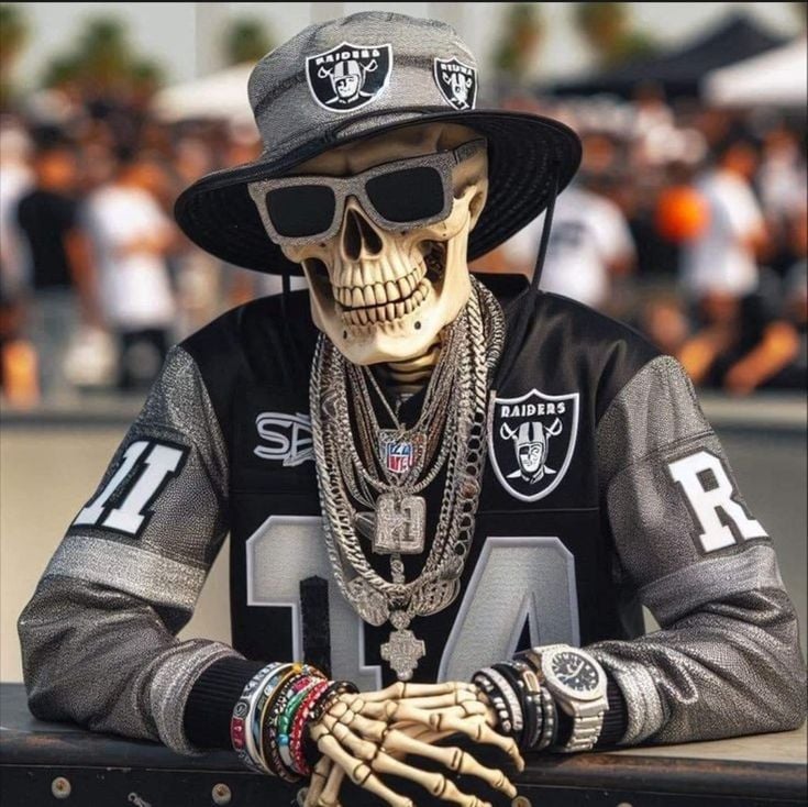 A skeleton wearing a Raiders jersey, hat, and sunglasses, adorned with chains, bracelets, and a watch at a sports event.