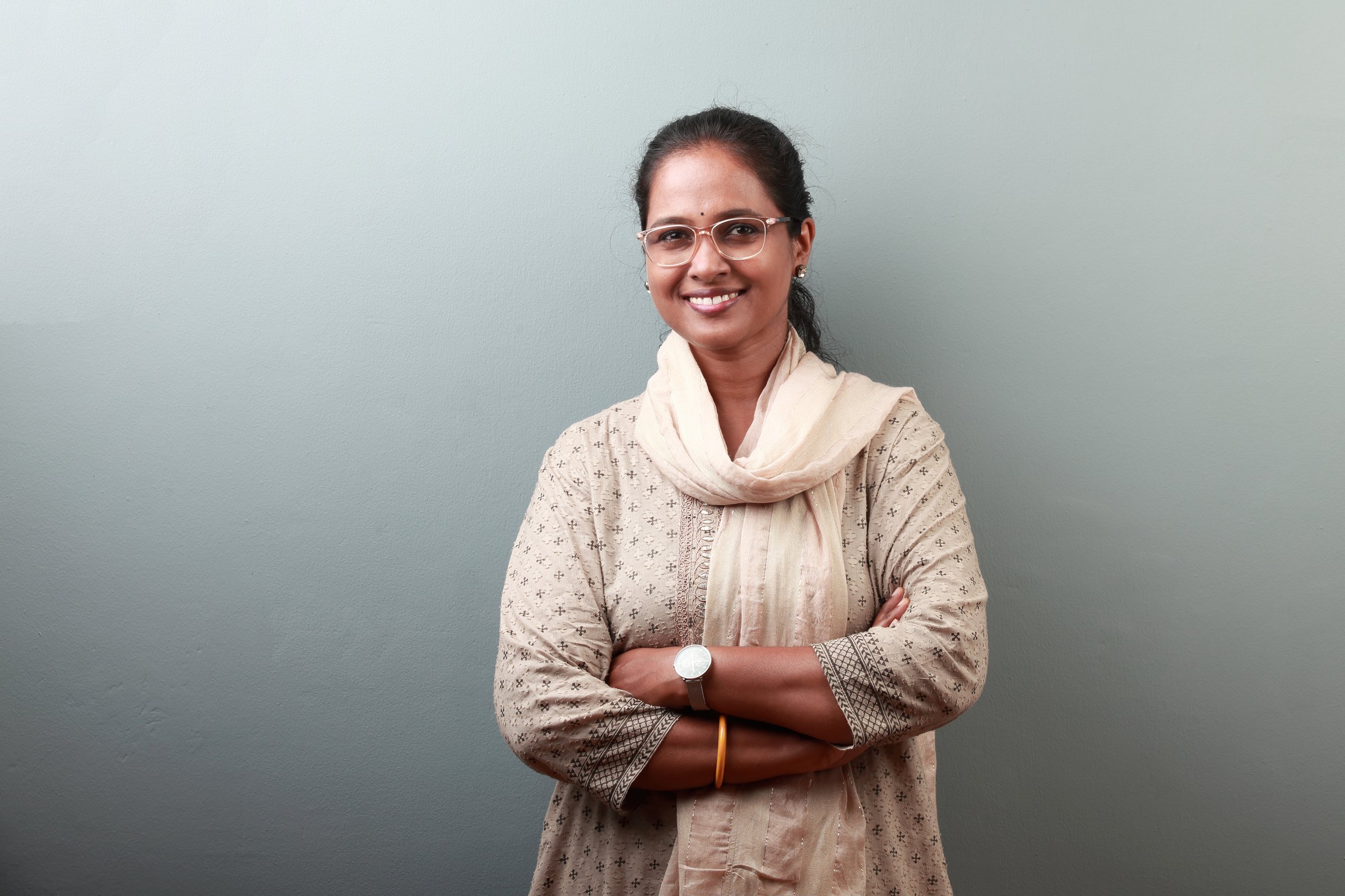 Portrait of a woman of Indian ethnicity wearing traditional dress with a smiling face