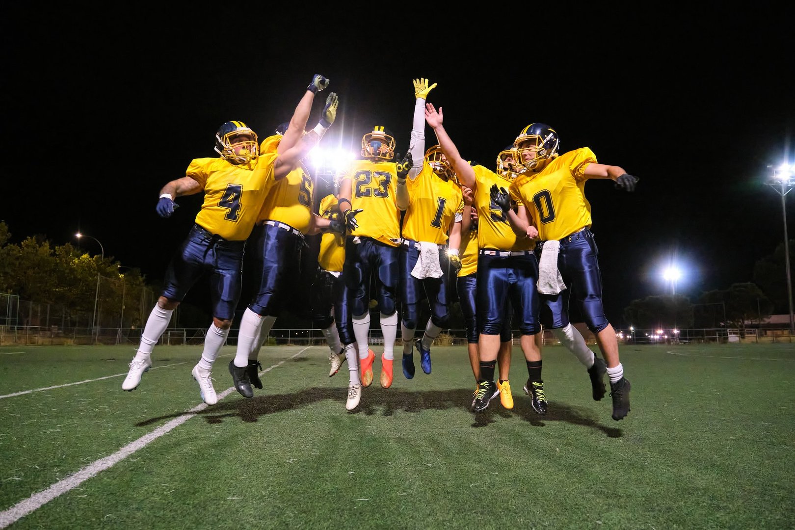 Players jumping in the air, expressing joy and teamwork after a successful game