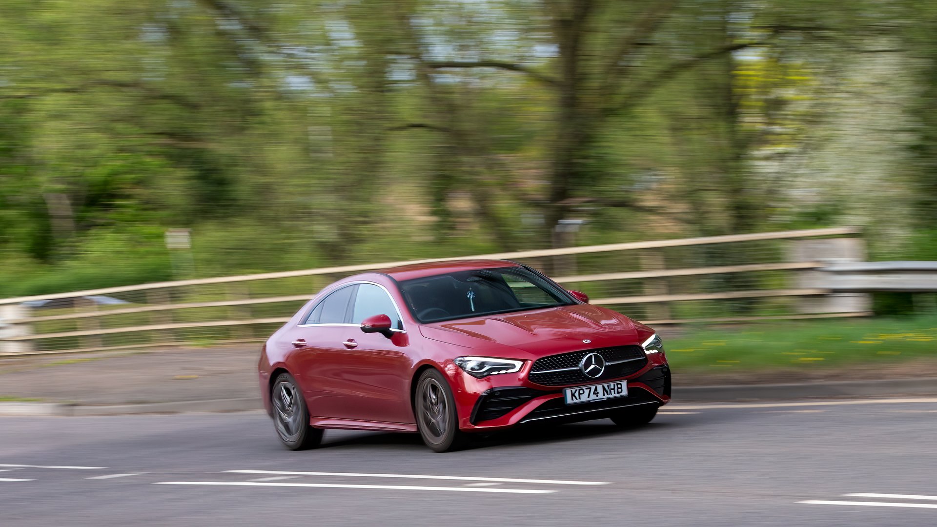Milton Keynes,UK - Apr. 14th 2025:   2024 red Mercedes Benz CLA 200 amg line hybrid electric car driving on a British  road