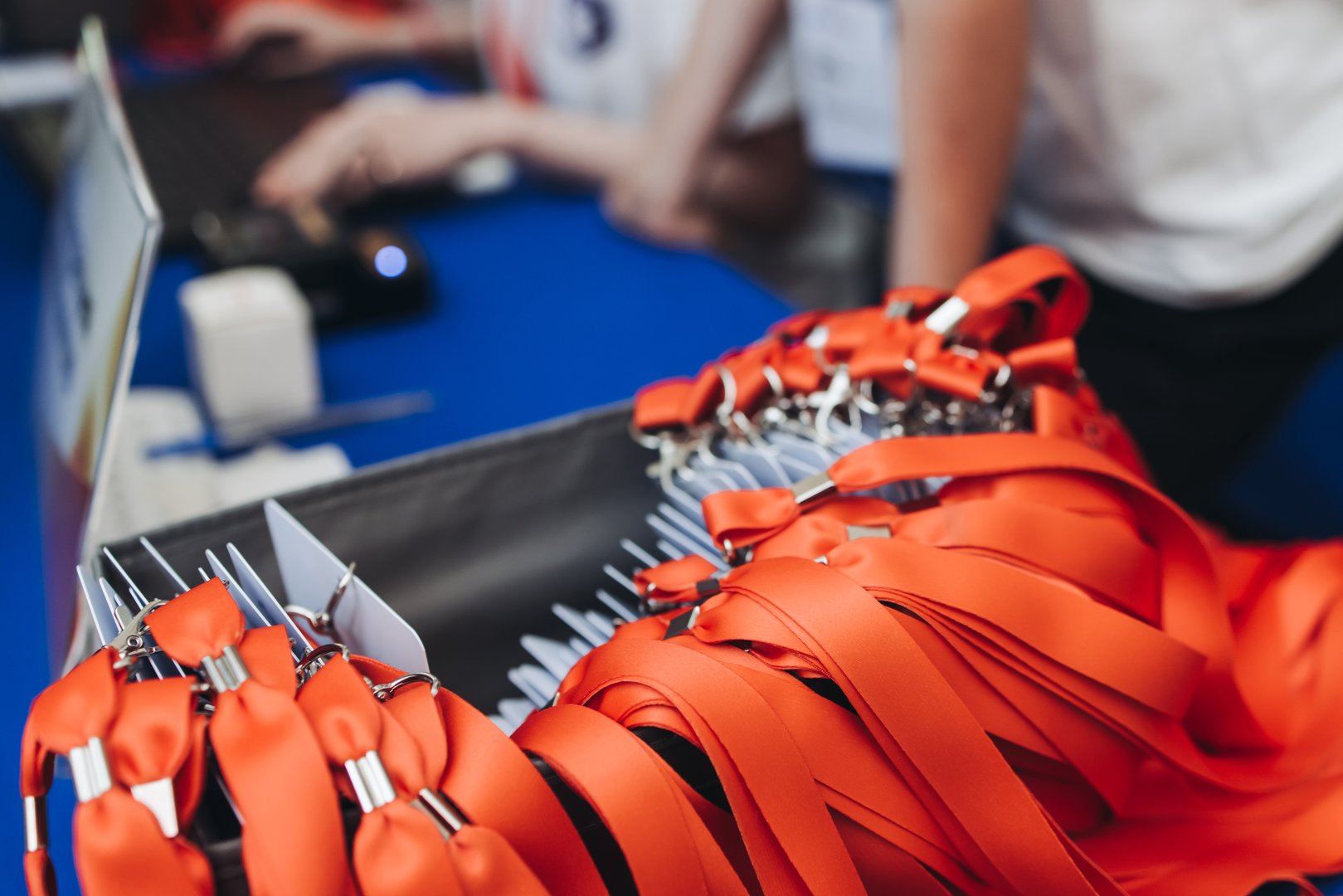 Process of checking in on conference congress forum event, registration desk table, visitors and attendees receiving lanyard with name badge and entry wristband bracelet and register electronic ticket