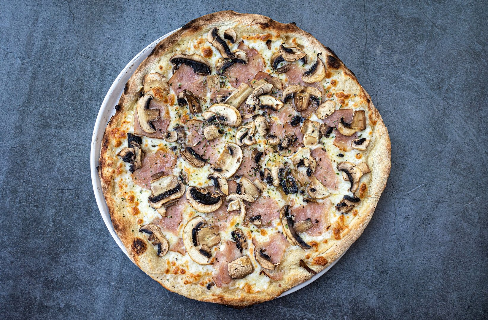 Spanish-style pizza with ham, salami, and mushrooms