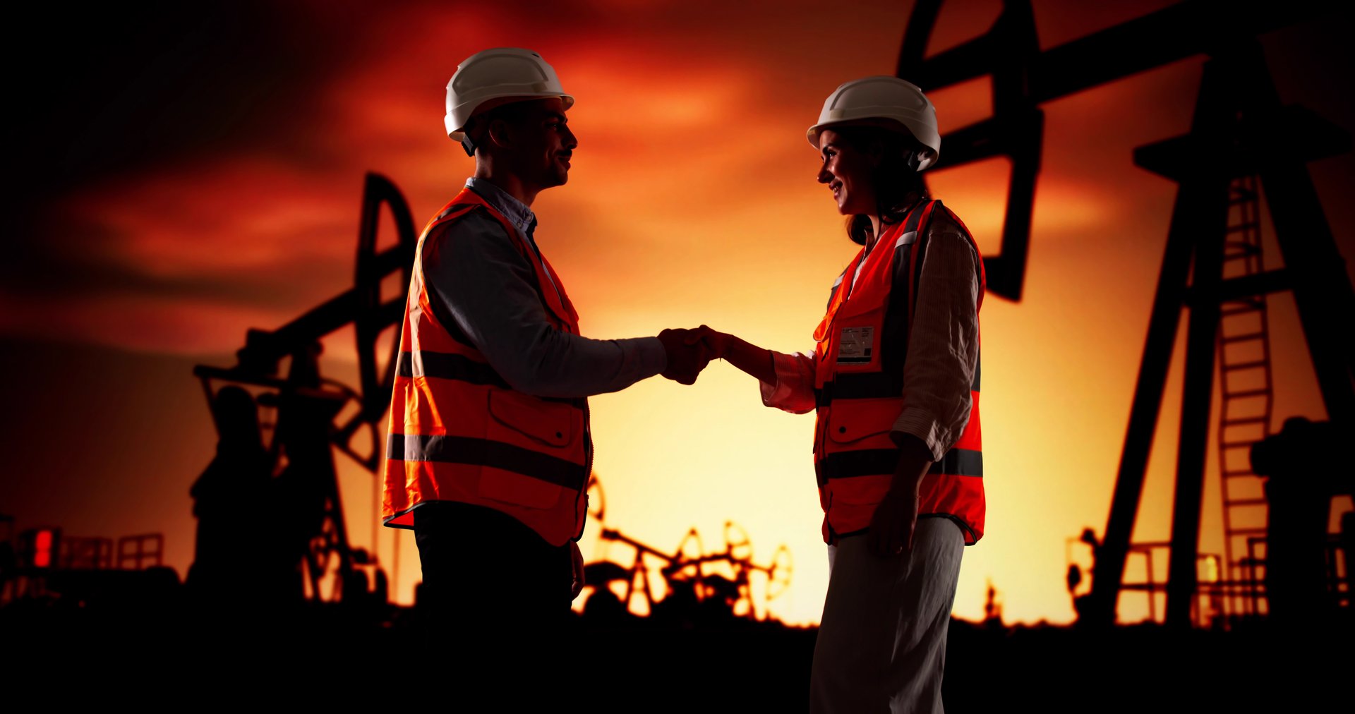 Corporate Engineers Shaking Hands At Oil Rig In Desert Sunset.