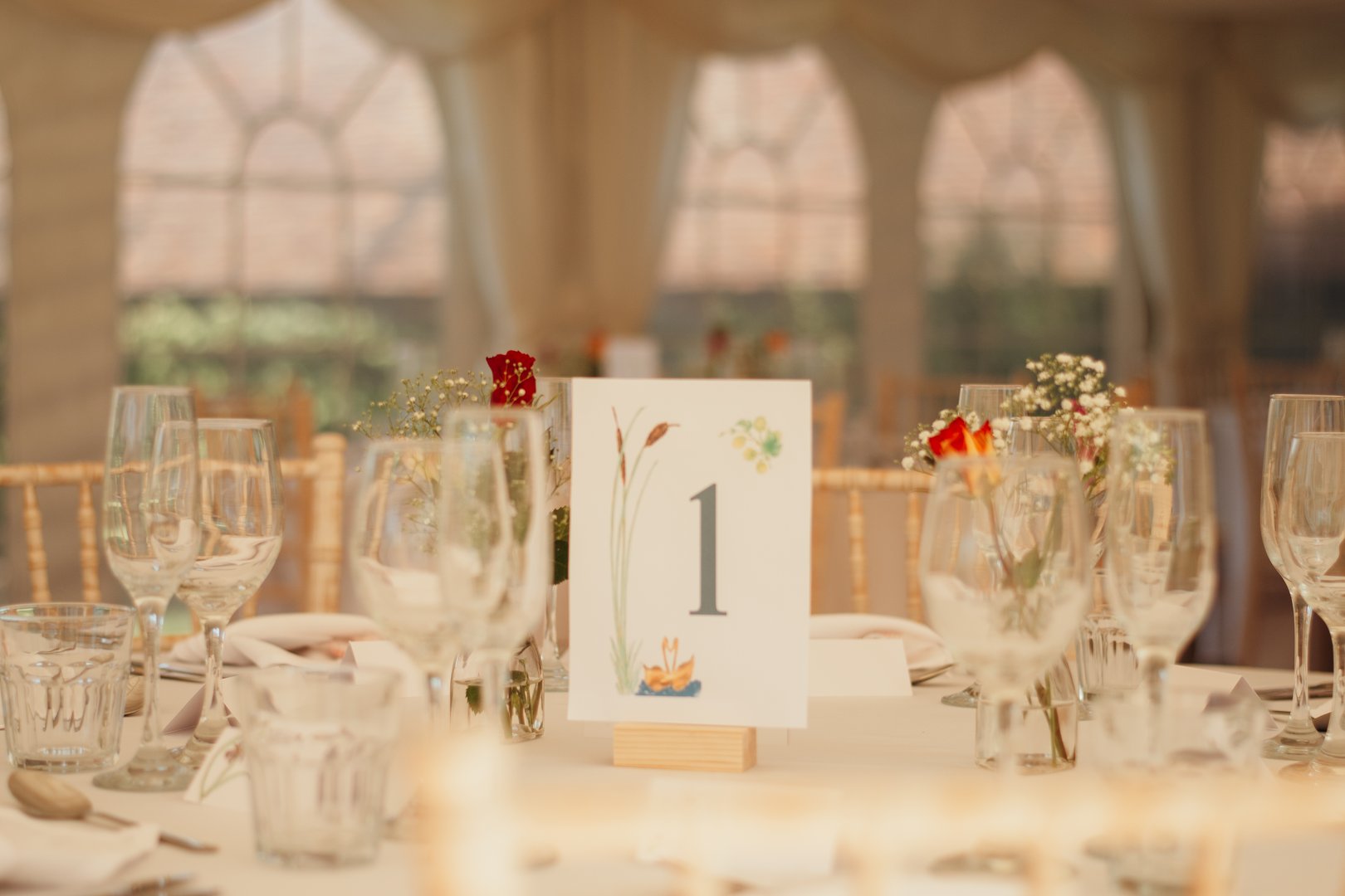 Close-up of a table number 1 displayed on a wedding day reception table. Elegant and organized detail for marriage celebration seating arrangements and festive décor.