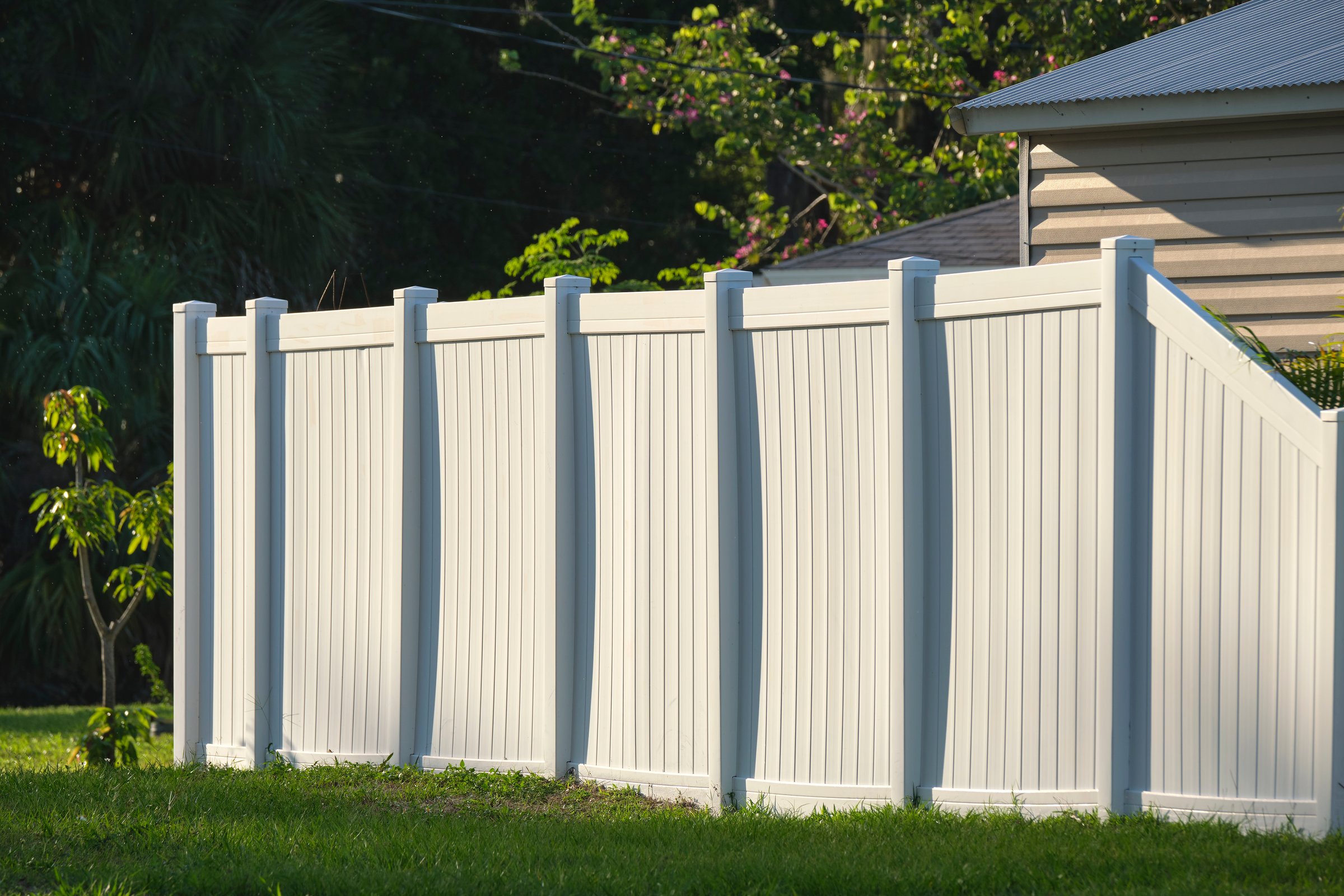 White plastic fence for back yard protection and privacy.