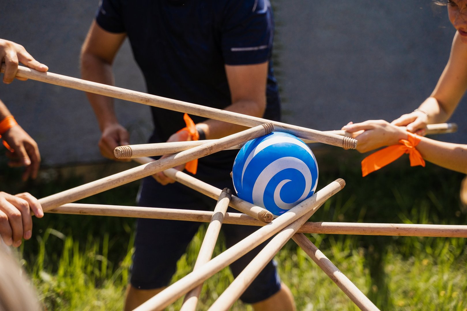 Teambuilding game for group of people for getting team spirit and increase friendship for colleagues. Team game with ball and sticks.