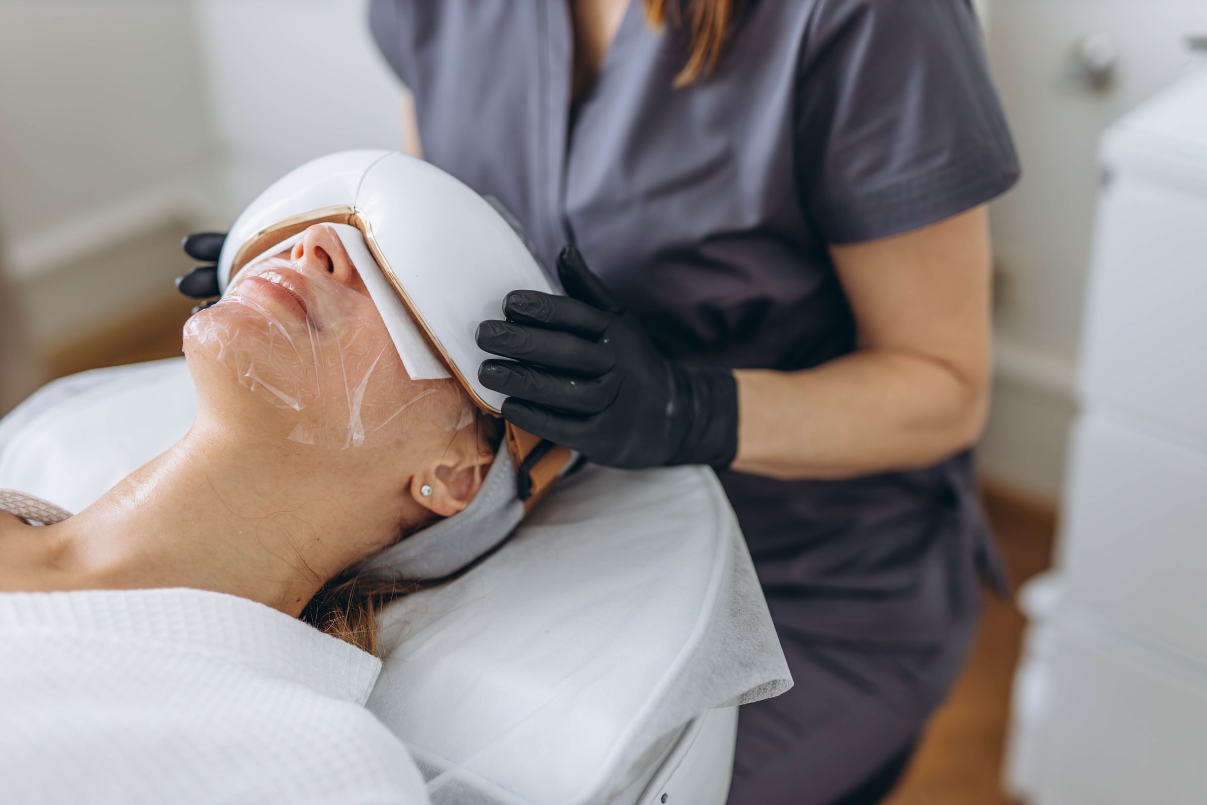 Young woman receives an eye massage using a device at a beauty salon, highlighting healthcare. High quality photo