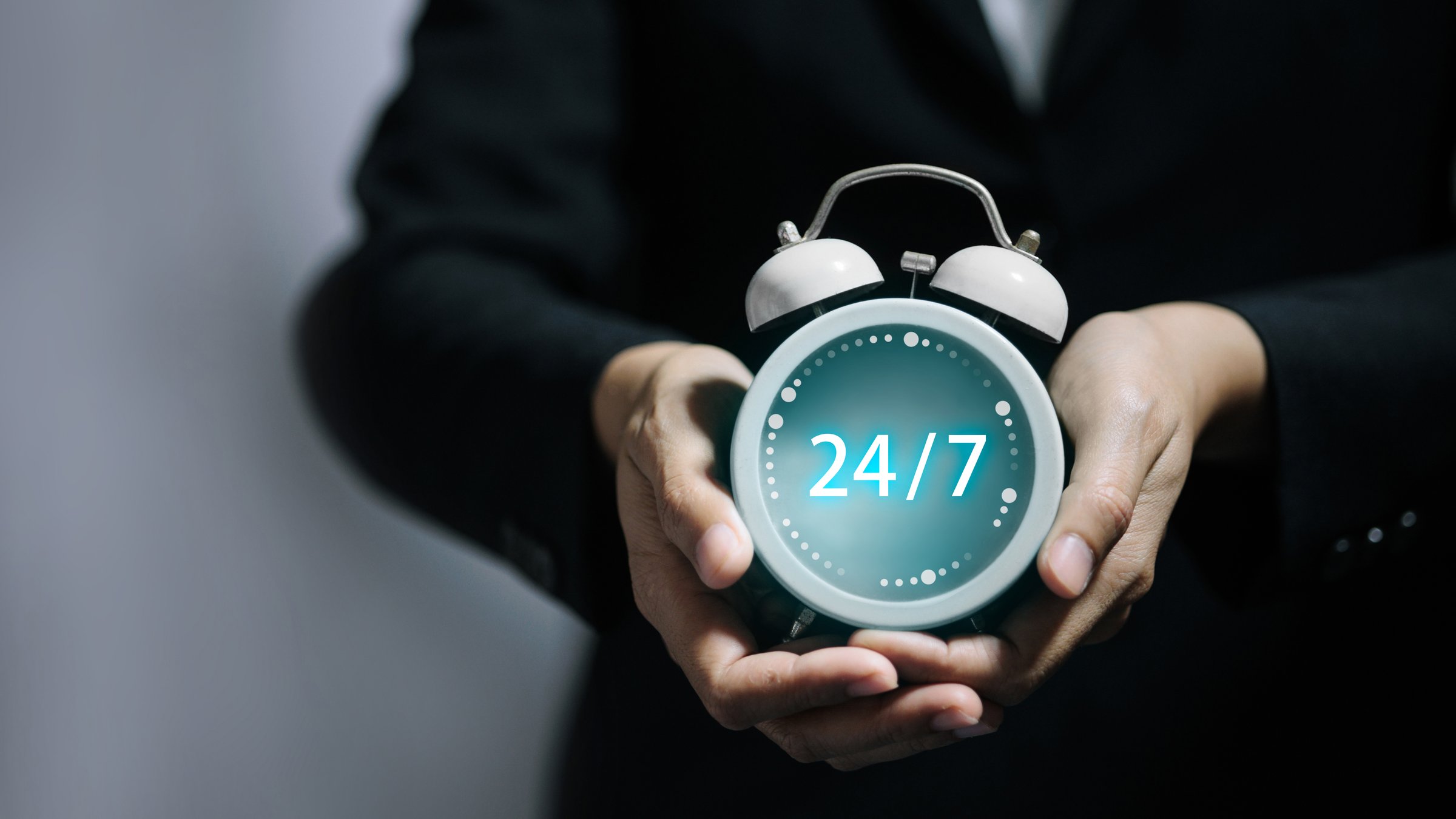Hands holding glowing 24/7 clock symbol, customer support, nonstop service, online business operation, and round-the-clock availability.