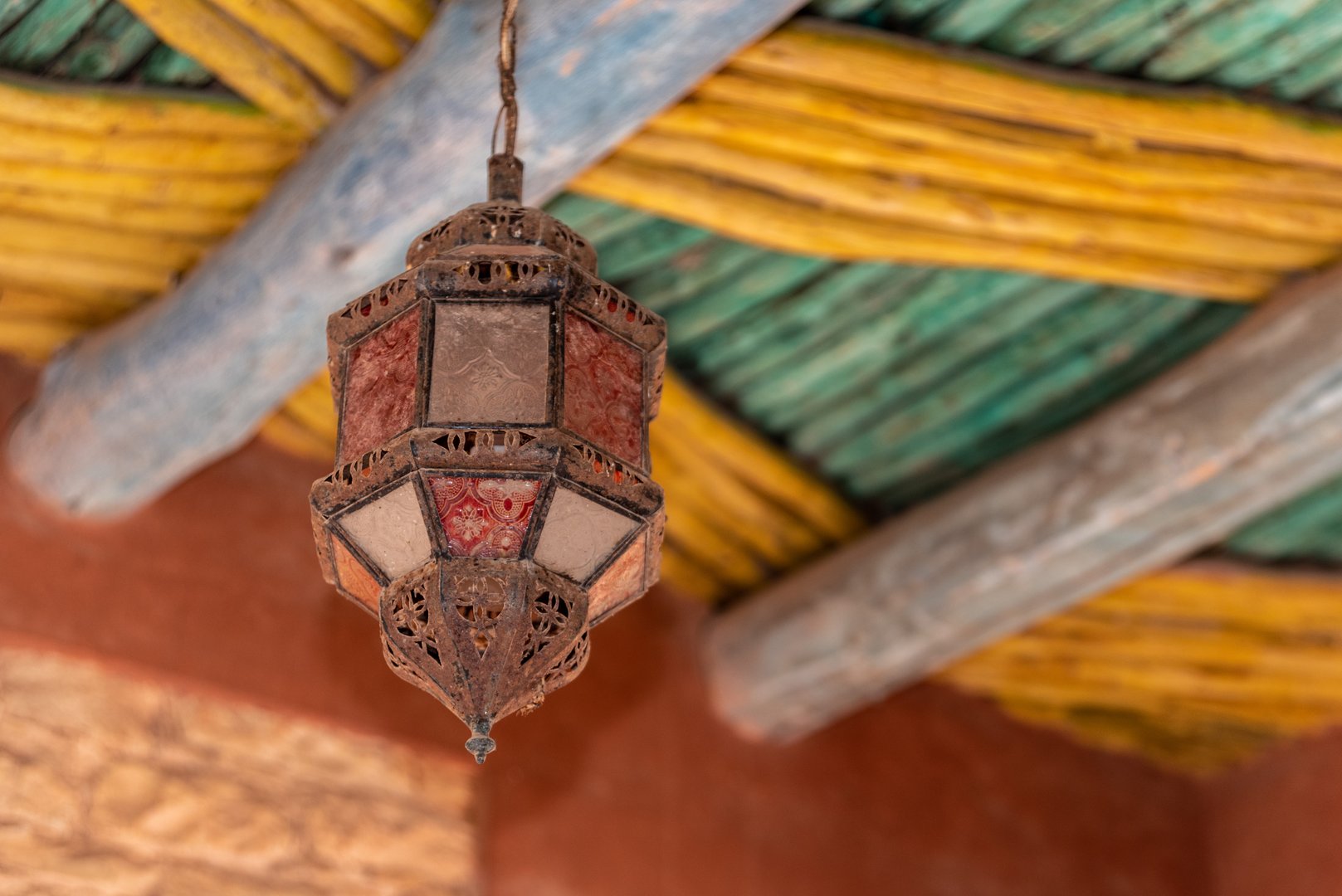 Old ancient Moroccan lantern hanging from a traditionally built wooden ceiling, Agadir in Morocco