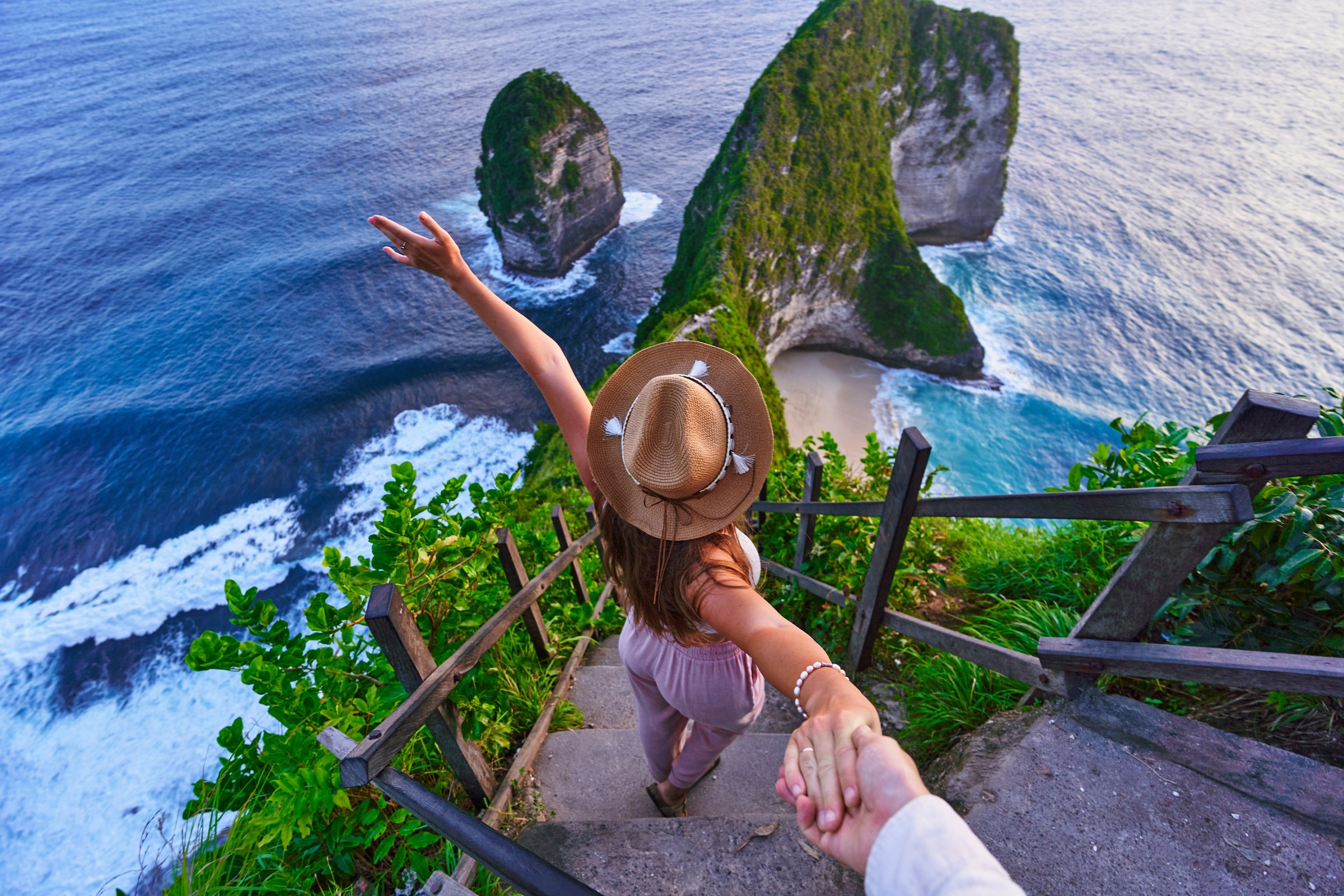 Follow me to scenic Kelingking beach. Traveling couple on vacation journey holiday to Nusa Penida Island in Indonesia, explore and travel to touristic beautiful destinations, honeymoon together