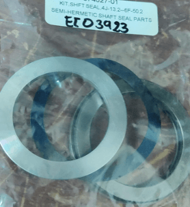Kit of semi-hermetic shaft seal parts, including metal rings, inside a plastic bag with a label displaying item numbers.