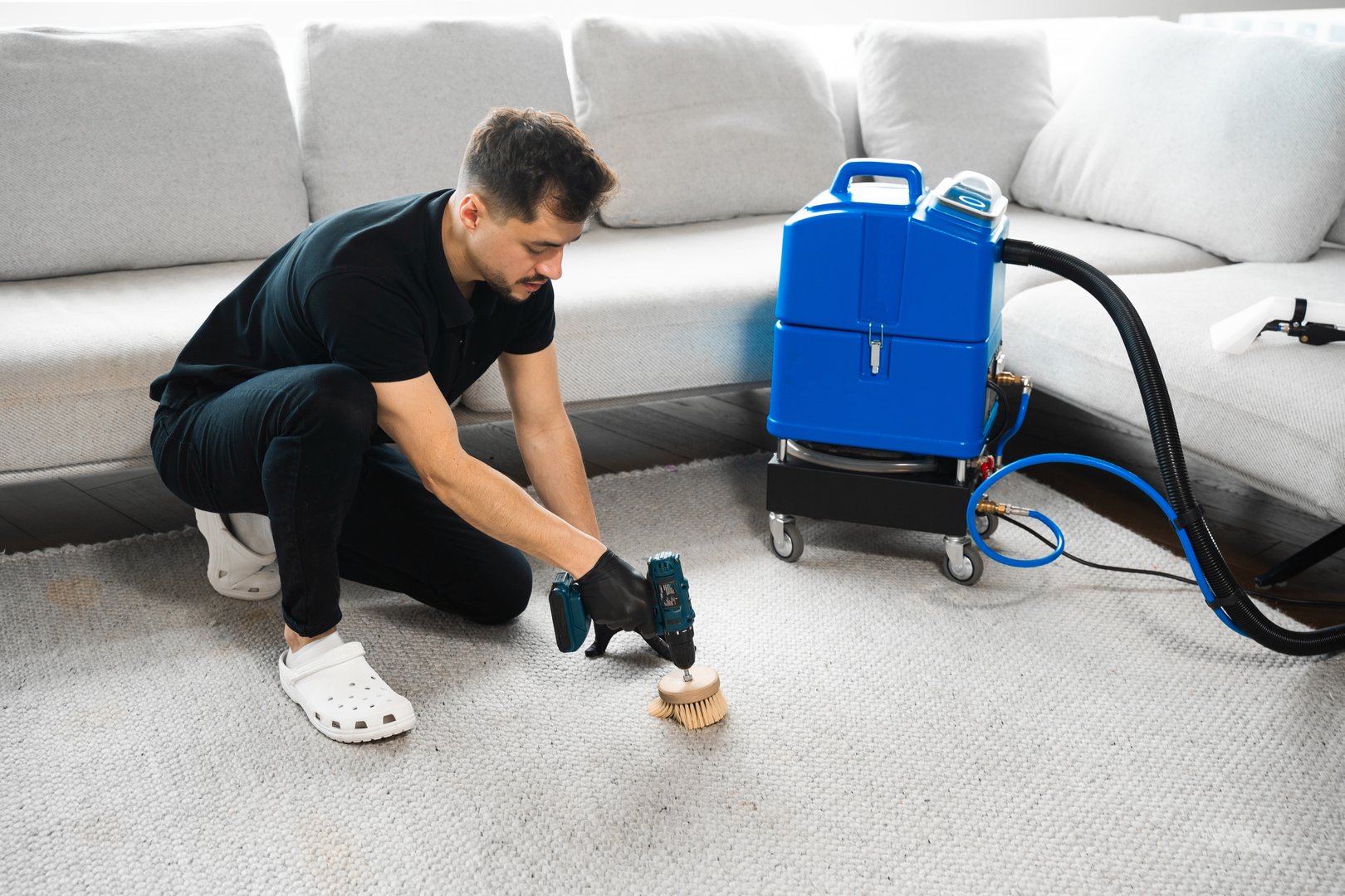 Cleaning the carpet at home using drill and brush. Easy removal of stains on carpet with drill and brush. Smearing detergent deep into fibers to clean carpet with drill and brush