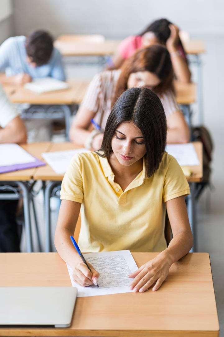 College Student writing notes taking test at High School . Teenager girl preparing university exam