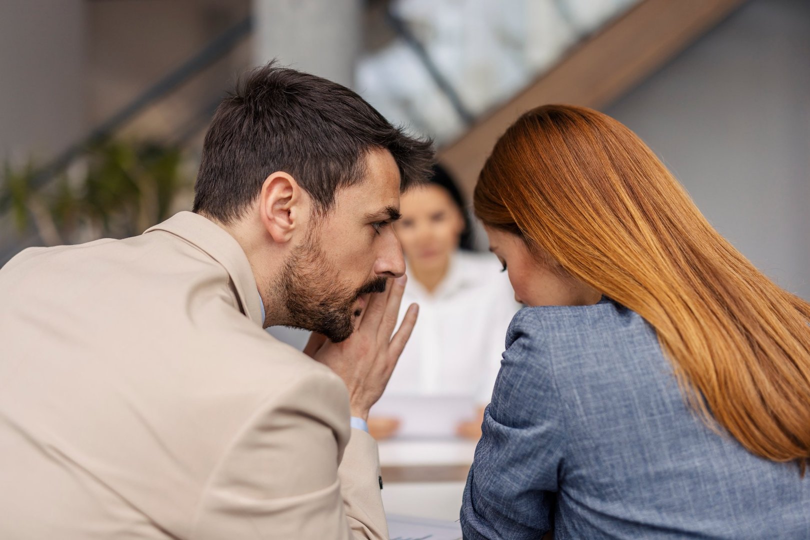 Businessman telling secrets and gossiping during the meeting at corporate office.