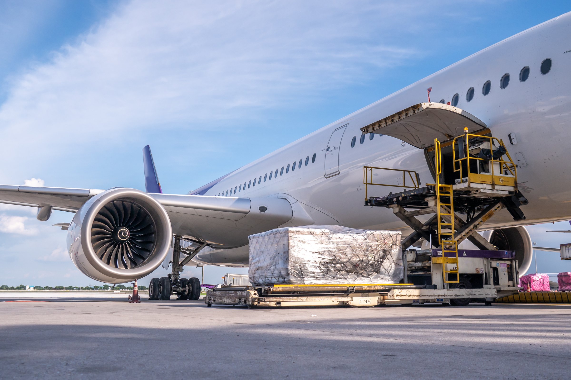 Air cargo logistic containers are loading to an airplane. Air transport shipment prepare for loading to modern freighter jet aircraft at the airport.