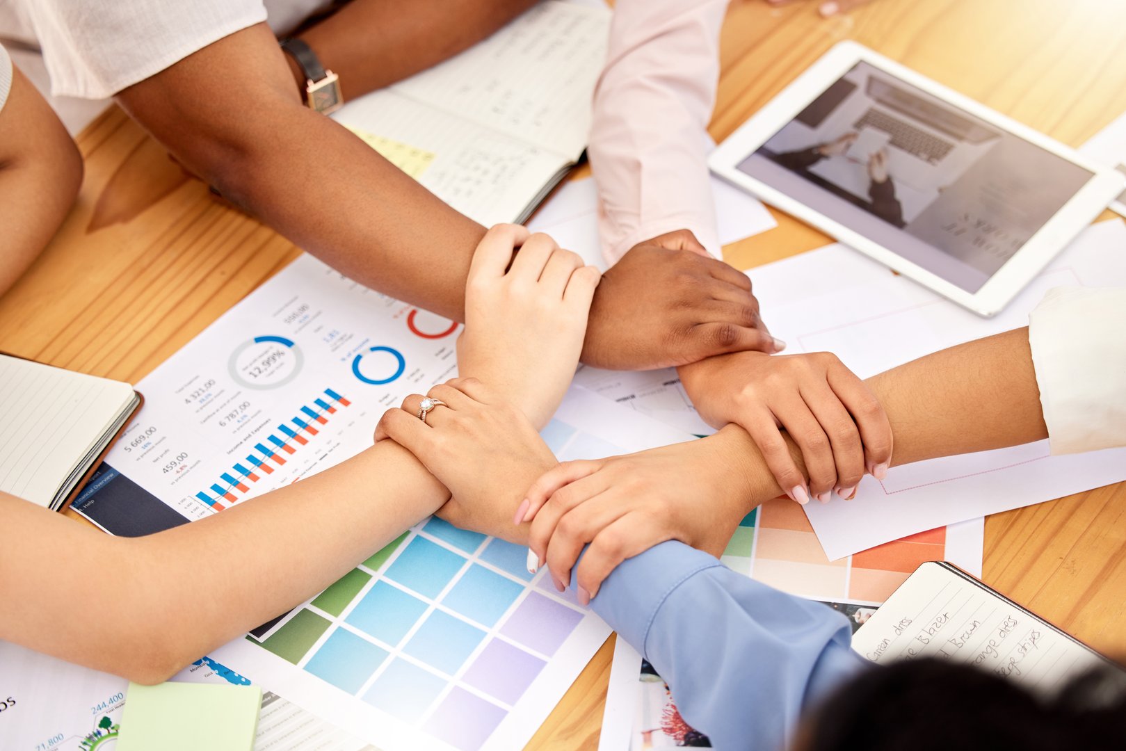 Team hands with teamwork, work support and community of office collaboration with project data. Working business team making hand circle to show corporate commitment, company unity and staff people