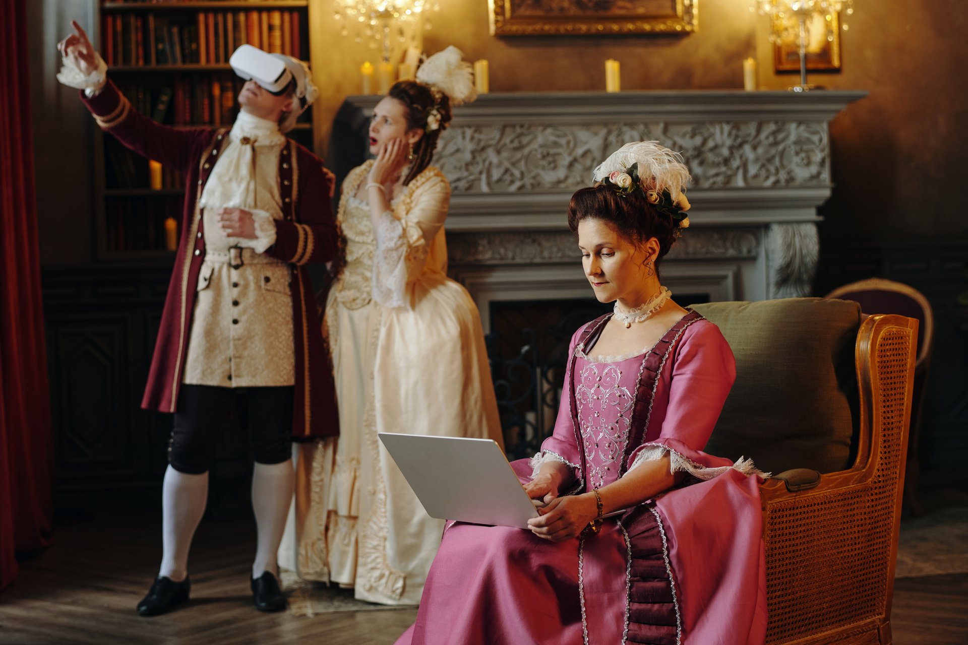 Woman using laptop while Caucasian young adult man in virtual reality headset gesturing and Caucasian young adult woman standing surprised
