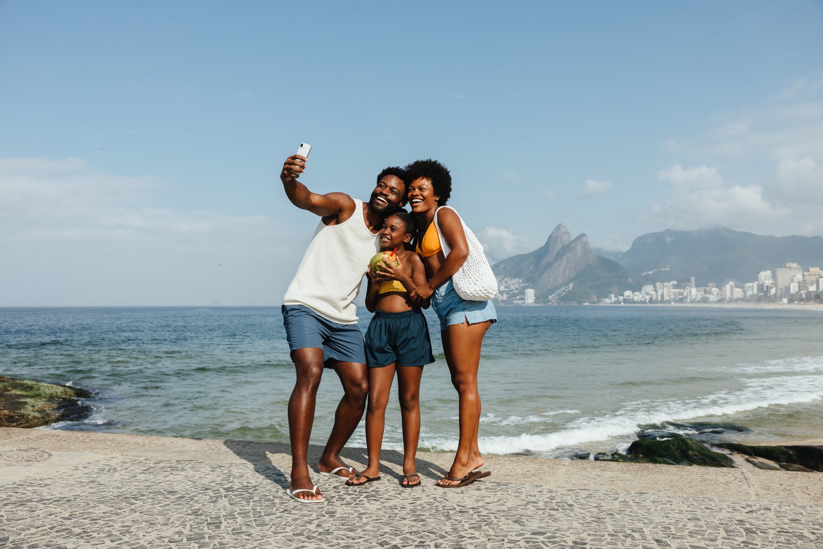 A joyful family captures a selfie on the iconic Ipanema Beach in Rio de Janeiro. A relaxed vacation scene, with the family radiating warmth and unity, highlighting the beauty of shared experiences.