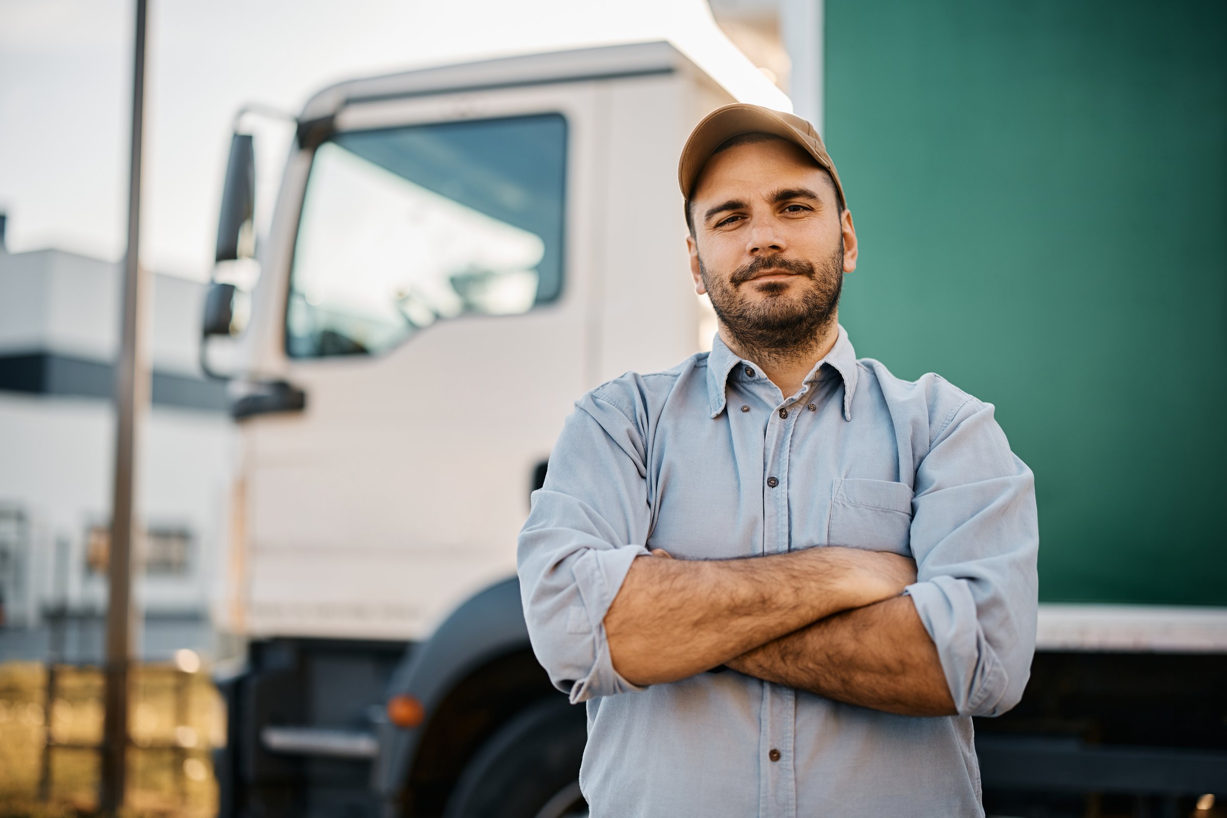Portrait of confident truck driver on parking lot looking at camera