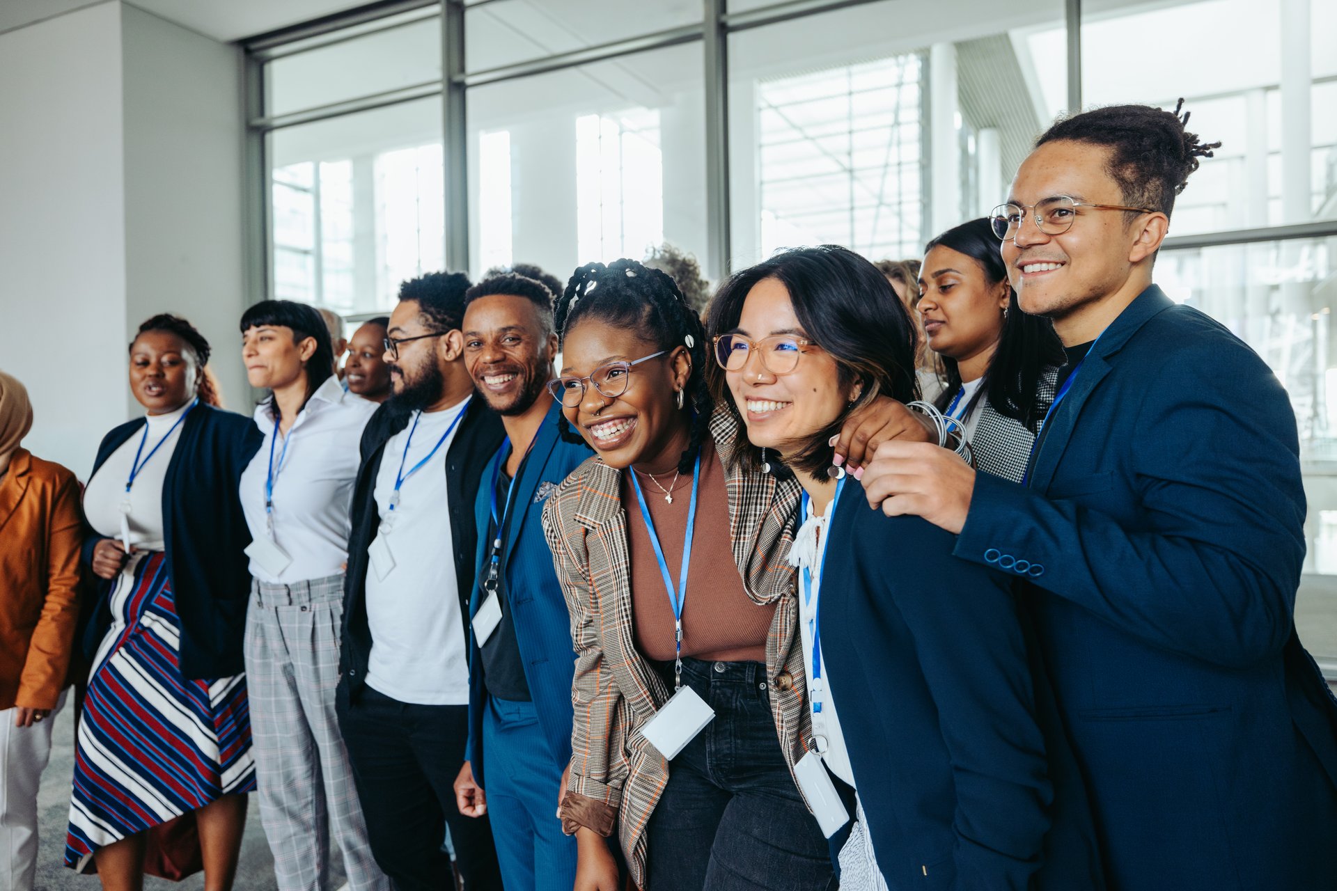 Group of diverse conference staff posing together for a photo, showcasing teamwork and collaboration at a professional event.