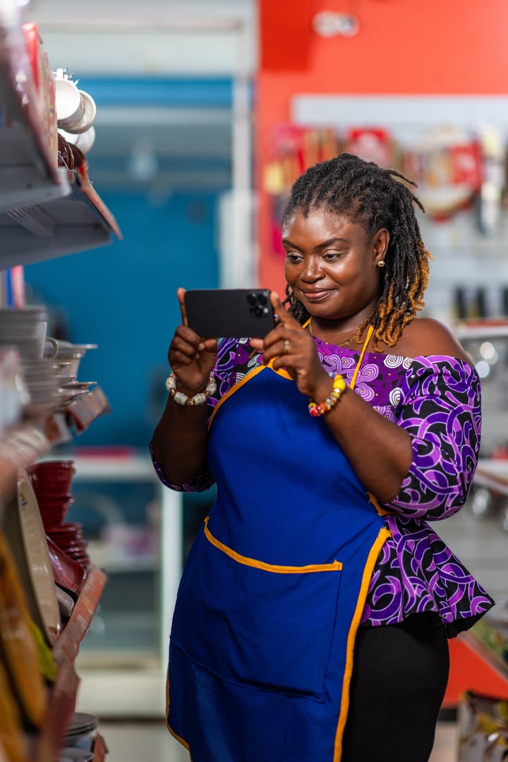 African businesswoman capturing product photos with smartphone for online marketing