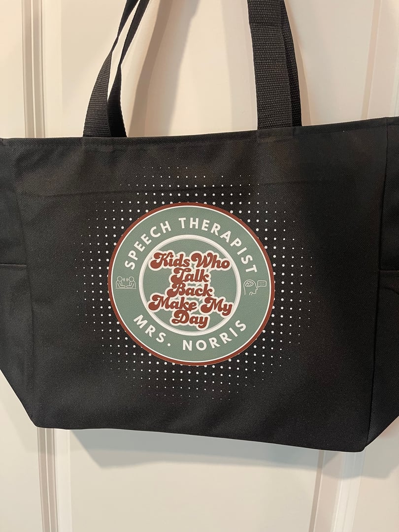 Black tote bag with a circular design reading Speech therapist, kids who talk back make my day, Mrs. Norris.