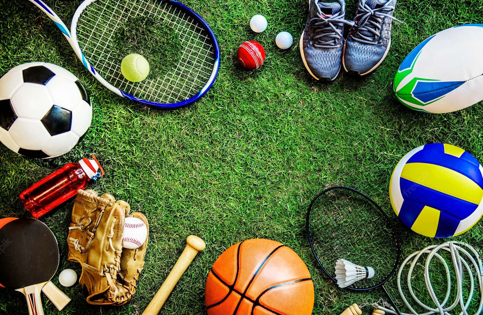 Various sports equipment collection on grass including balls, rackets, and athletic gear from multiple sports