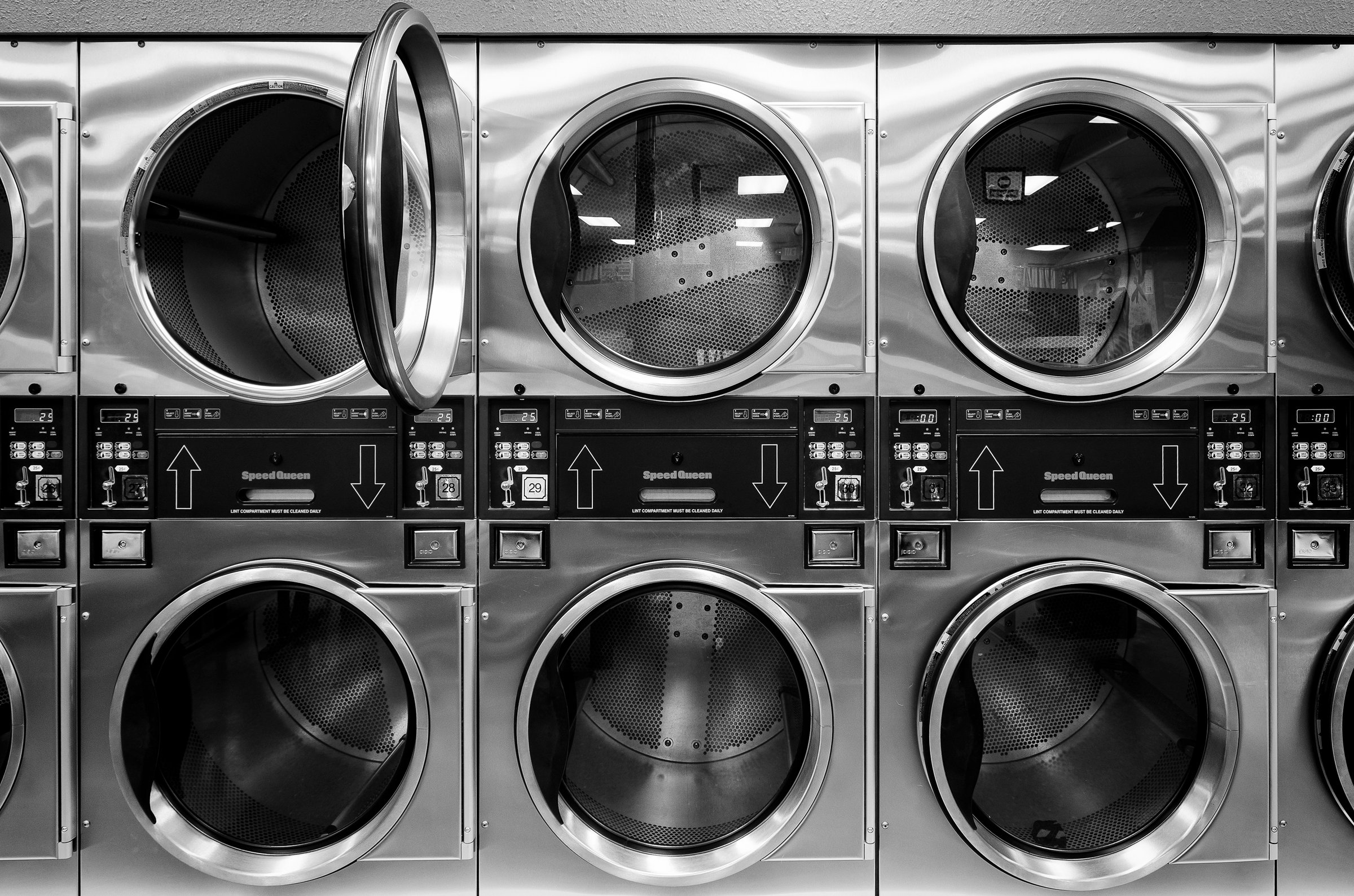 An Array of washing machines in a 24/7 laundromat