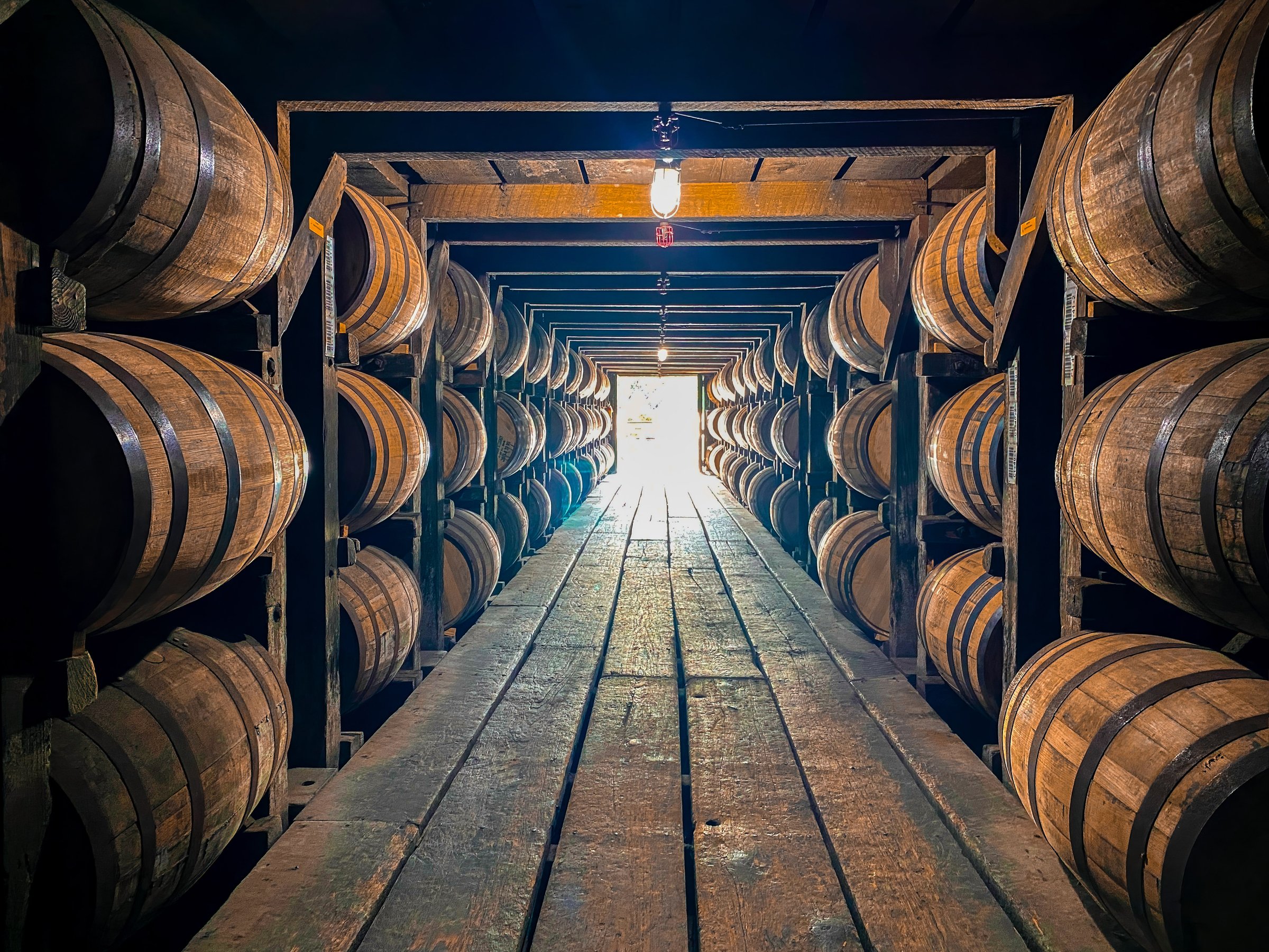 Wooden bourbon barrels stacked up and aging in a rickhouse in Kentucky