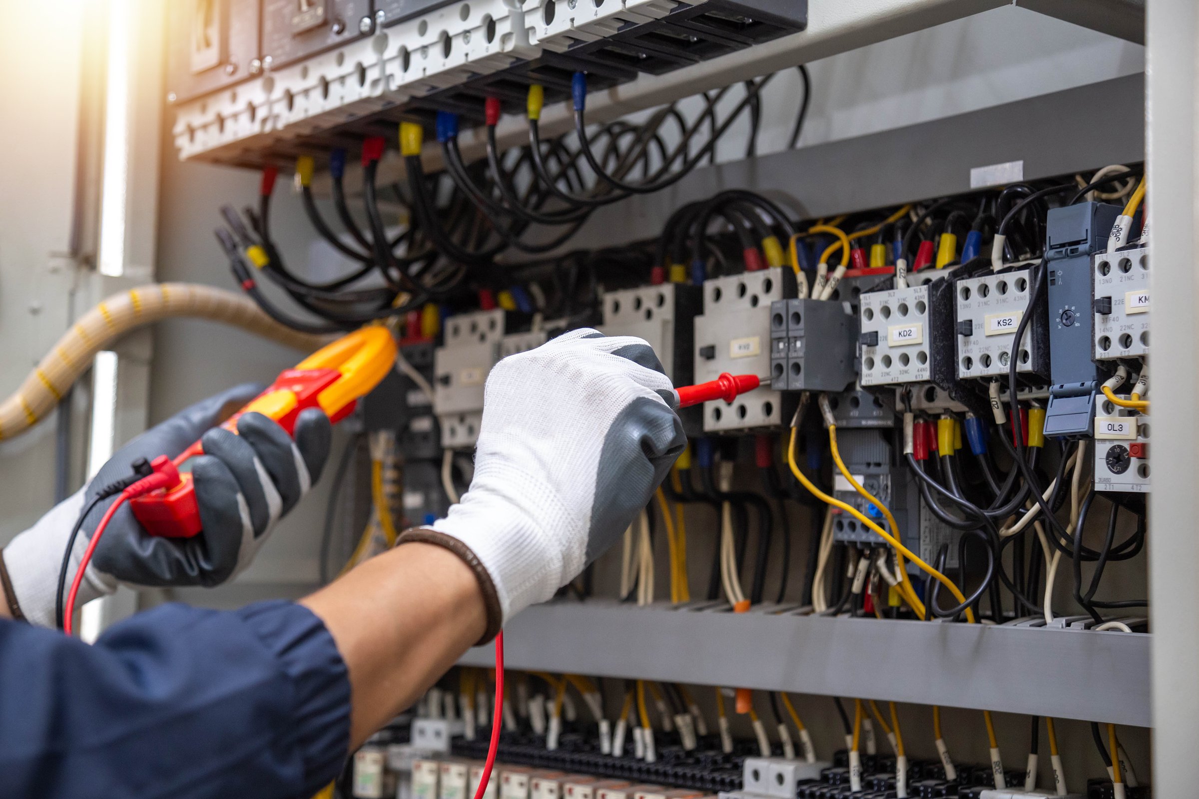 Checking the electrical system, an electrician is using an electric meter to check the electrical system at a control cabinet. for safety
