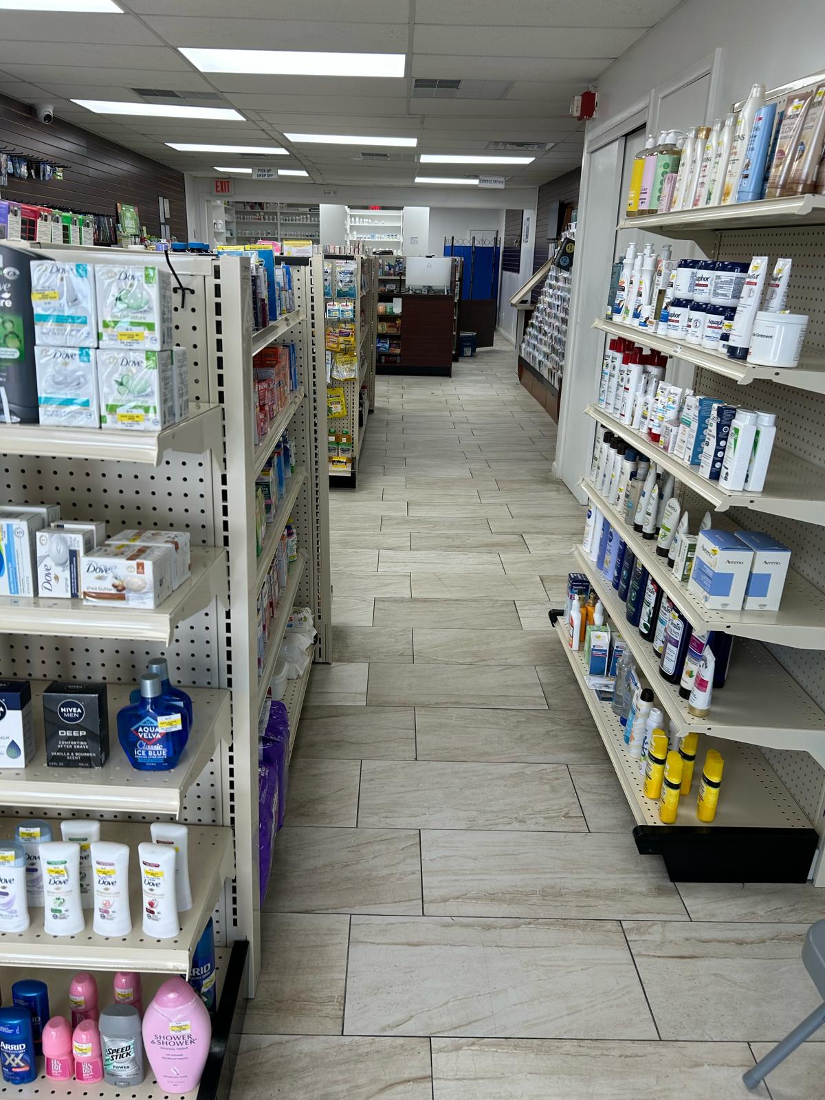 Interior of a pharmacy with shelves stocked with various health and beauty products in a well-lit aisle.