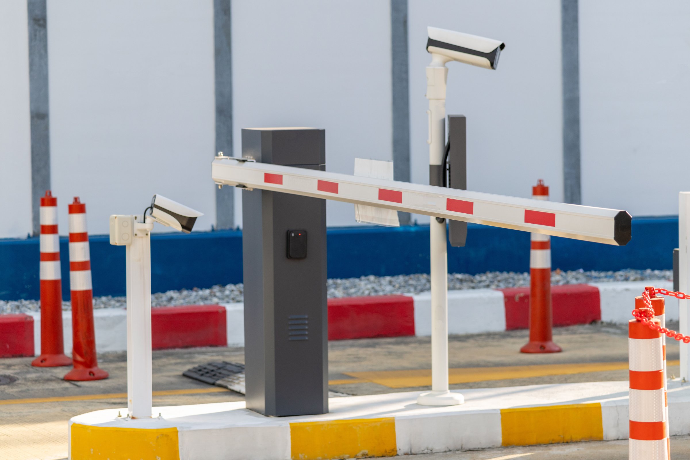 A traffic barrier with a security camera of car park.