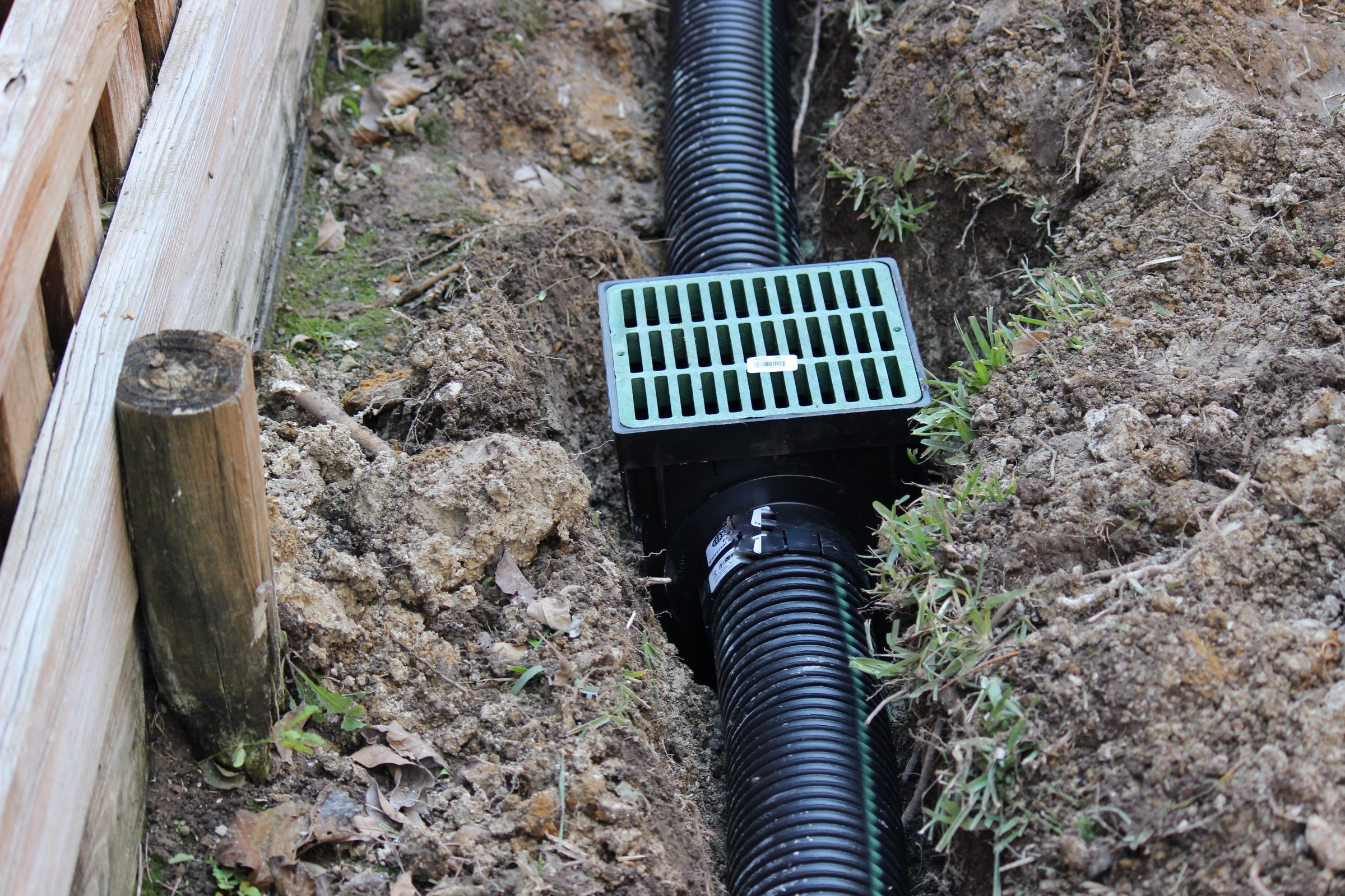 Drainage ditch. Laying a drainage pipe using rain drainage sewage pipe and box. Earthwork.