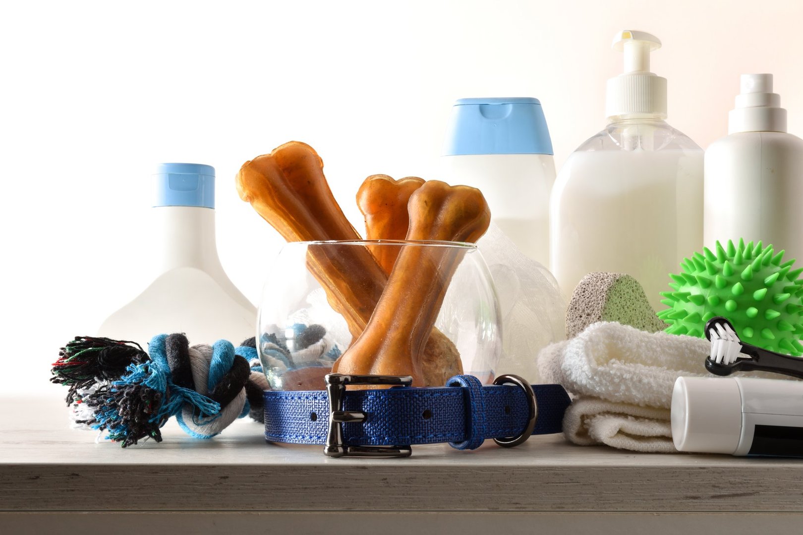 Dog bath products on wooden cabinet in a bathroom with white isolated background. Front view. Horizontal composition.